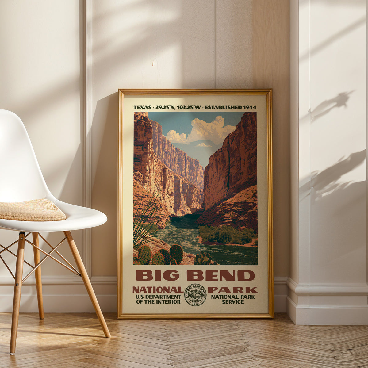 Big Bend National Park vintage WPA art in an oak frame leaning by a white chair on a wood floor