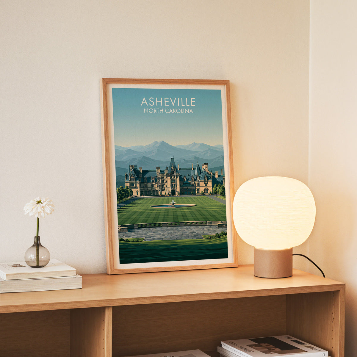 North Carolina chateau print in a slim oak frame on an oak console beside daisies in a glass jar