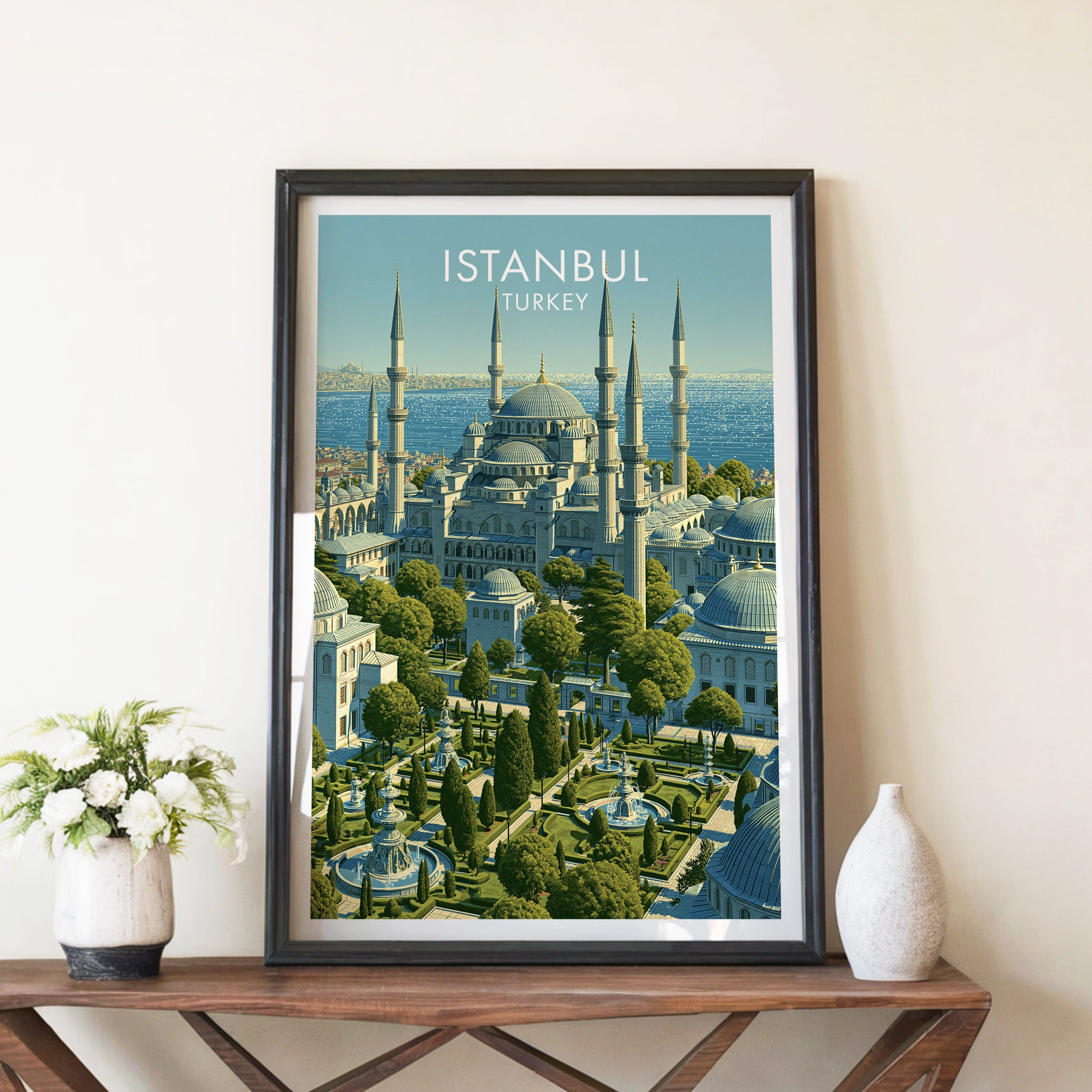 Blue Mosque Istanbul Turkey travel poster in a black frame on a wooden console table with white flowers