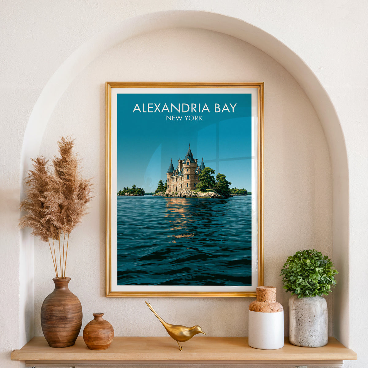 New York river castle poster in a gold frame in an arched niche with pampas grass and a brass bird