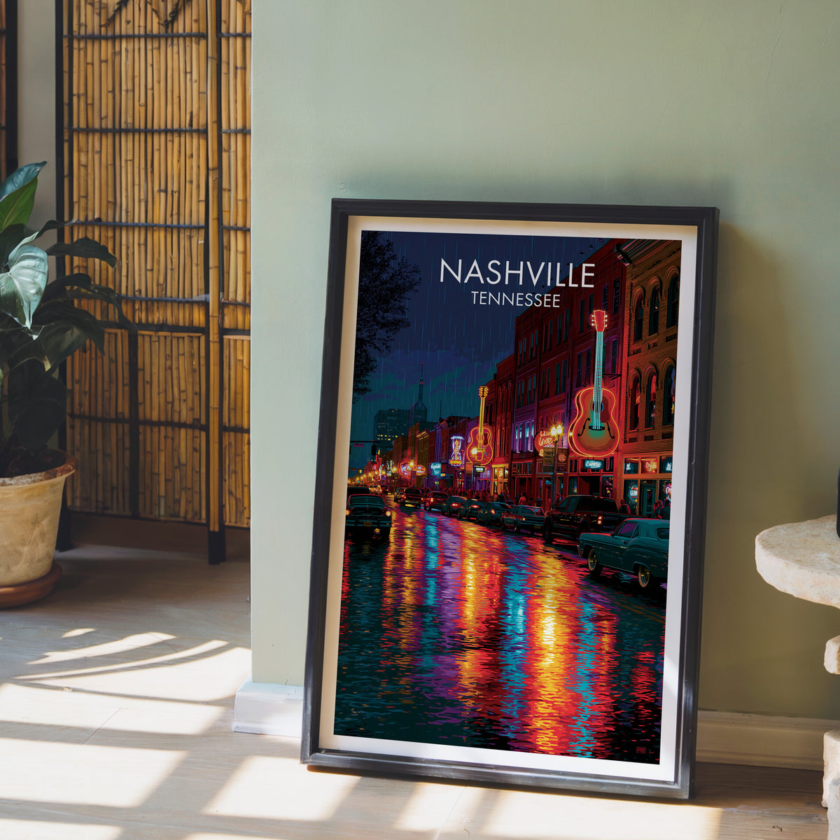 Nashville neon street print in a black frame by a sage wall with a bamboo screen and an orchid