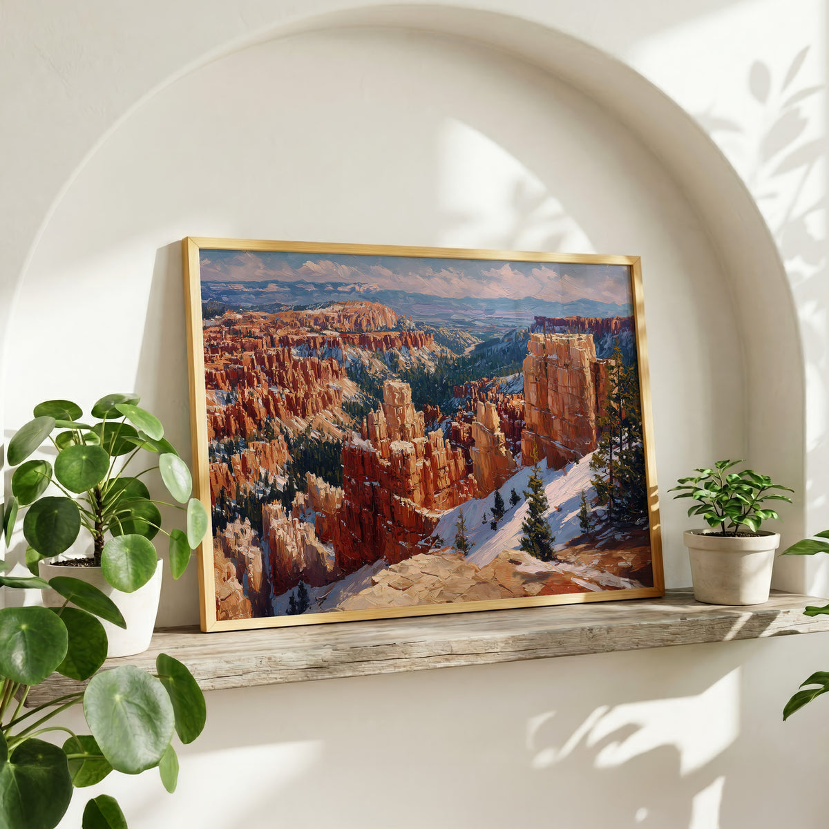 Bryce Canyon oil painting wall art in a gold frame on a rustic wood shelf with potted plants