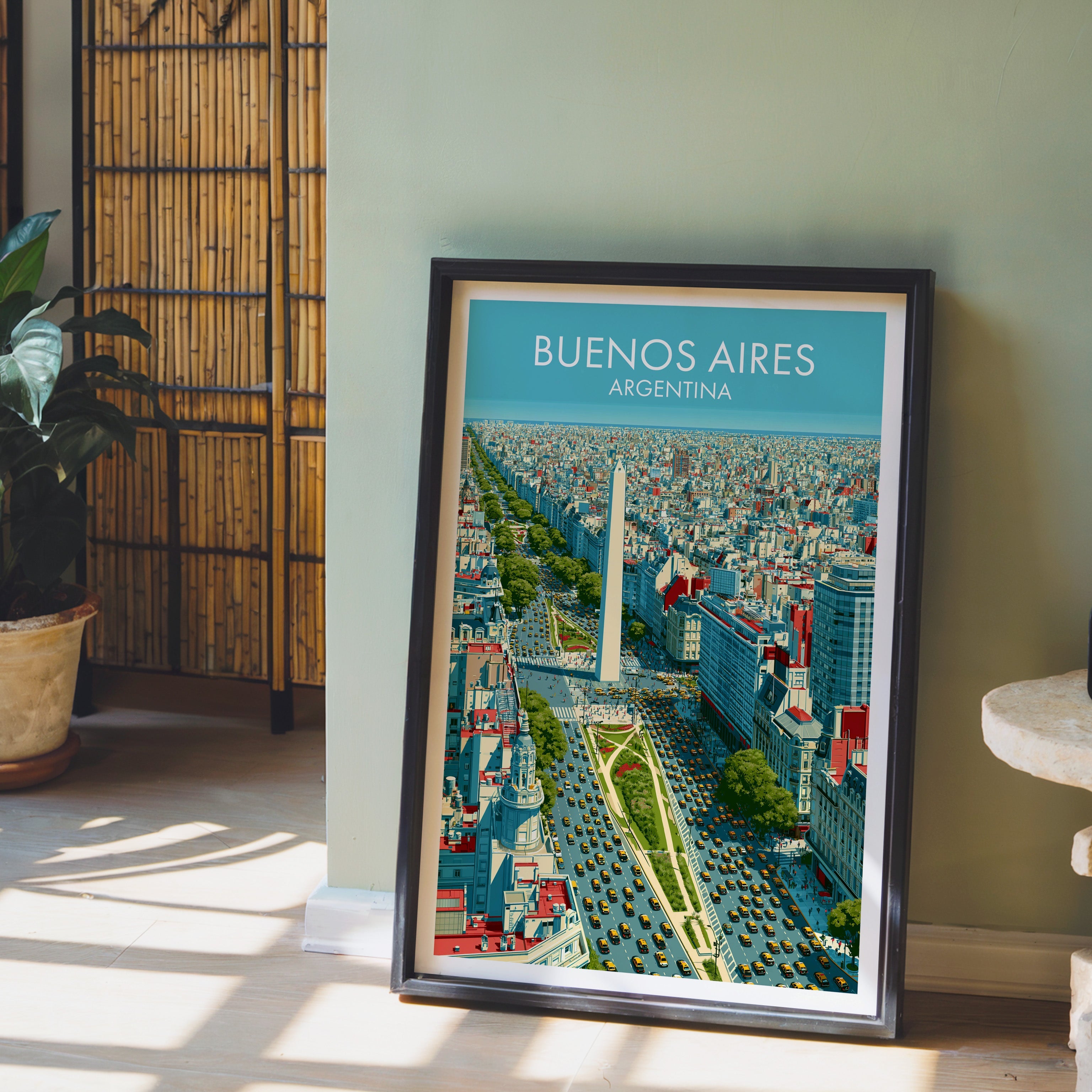 Buenos Aires avenue print in a dark brown frame on light wood floor by a sage wall and bamboo screen