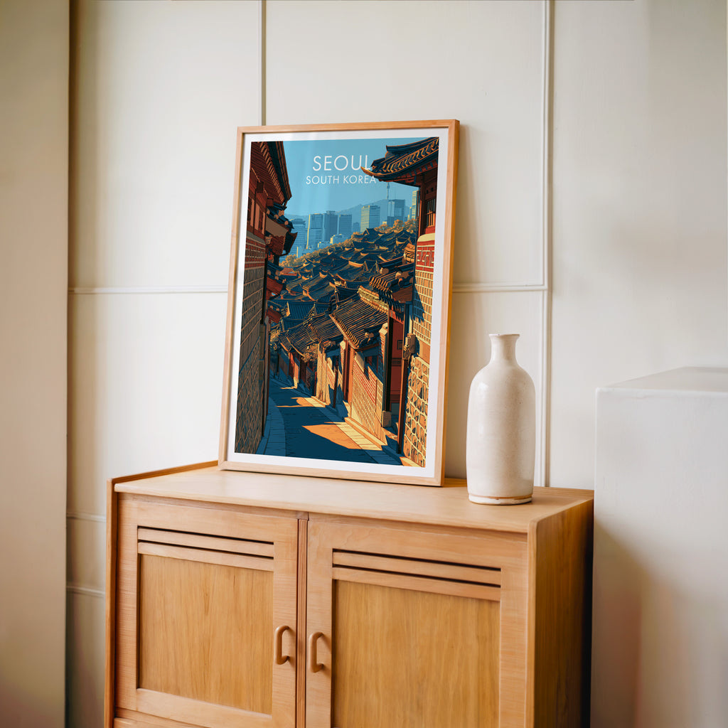 Small Bukchon Hanok Village Seoul travel poster in an oak frame on a mid-century sideboard with a ceramic vase