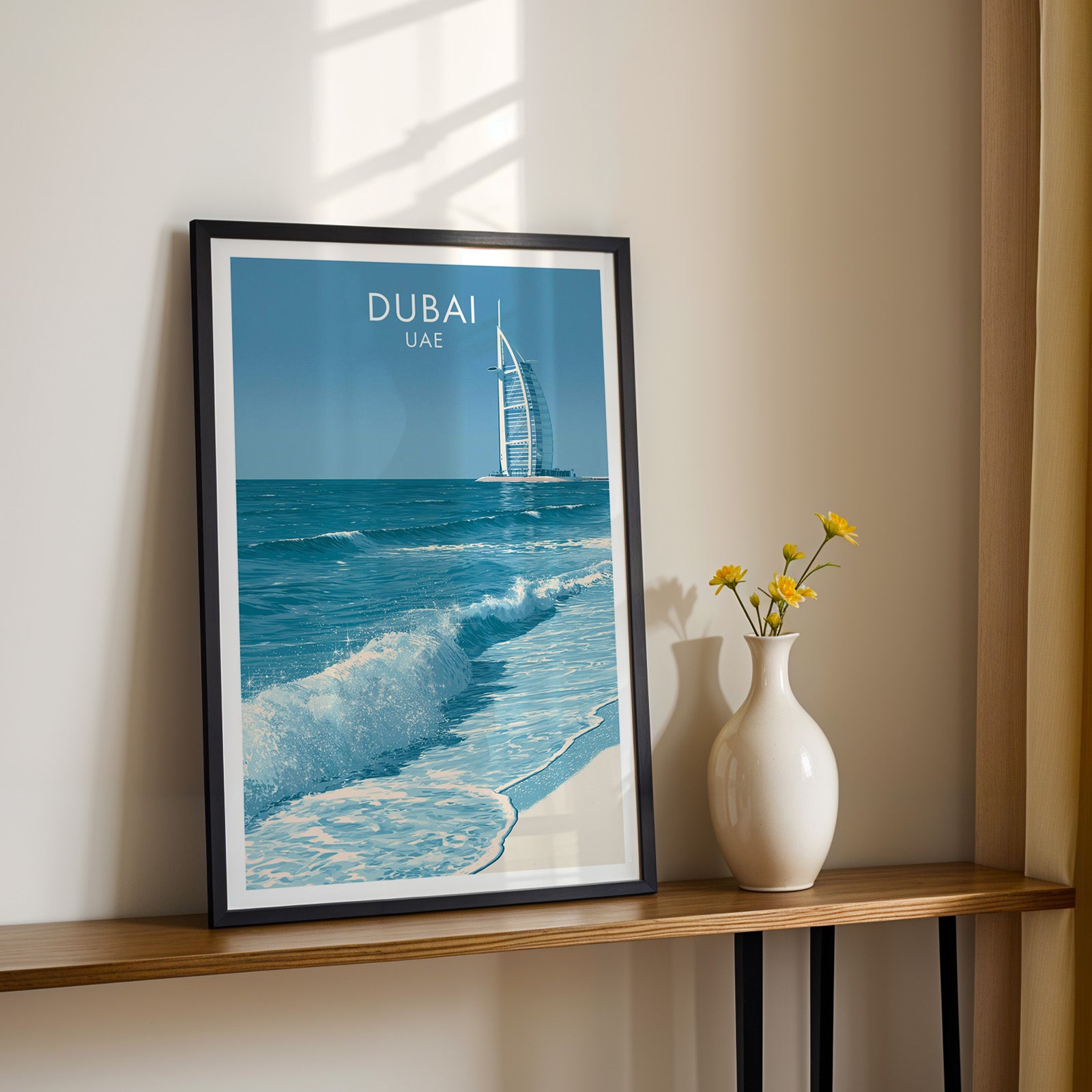 Black framed Burj Al Arab Dubai UAE print on a narrow hallway console in sunlight, styled with yellow flowers