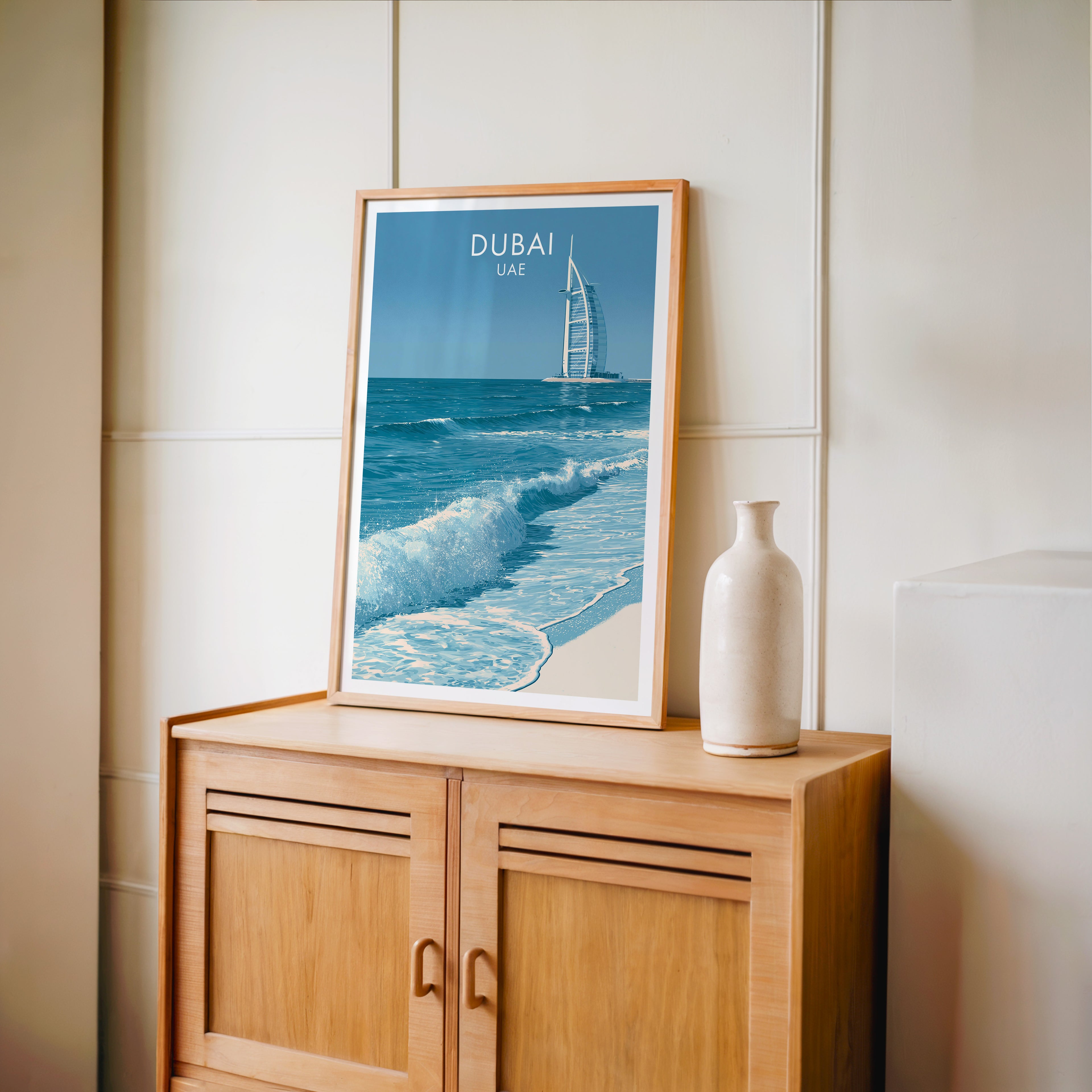 Small Burj Al Arab Dubai UAE travel poster in an oak frame on a mid-century sideboard with a ceramic vase