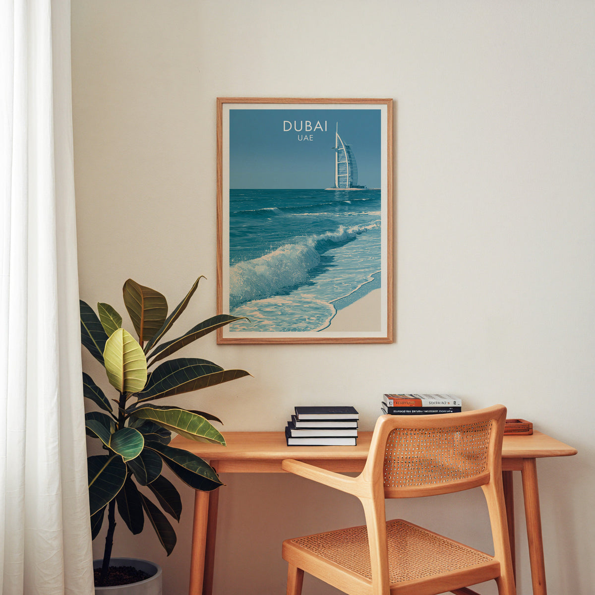 UAE travel poster in an oak frame above a wooden home office desk with a cane chair and books