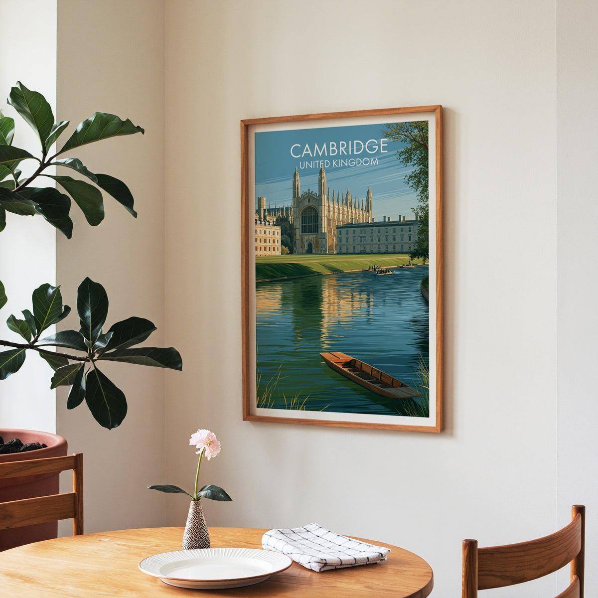 Cambridge poster, walnut frame in a dining corner above a round table and a fiddle-leaf fig