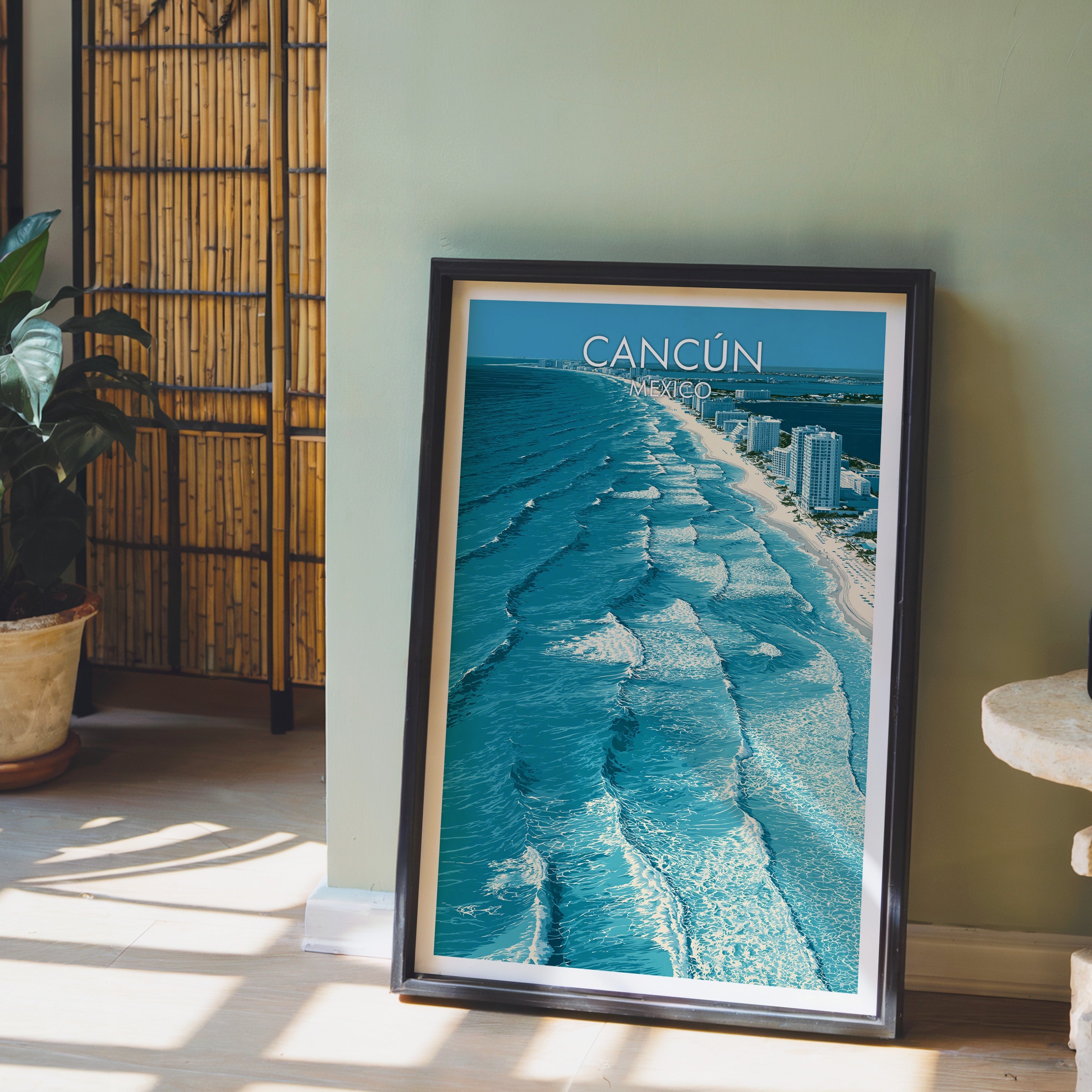 Rolling white surf over Cancun sand, black frame leaning on a pale wood floor against a sage-green wall.