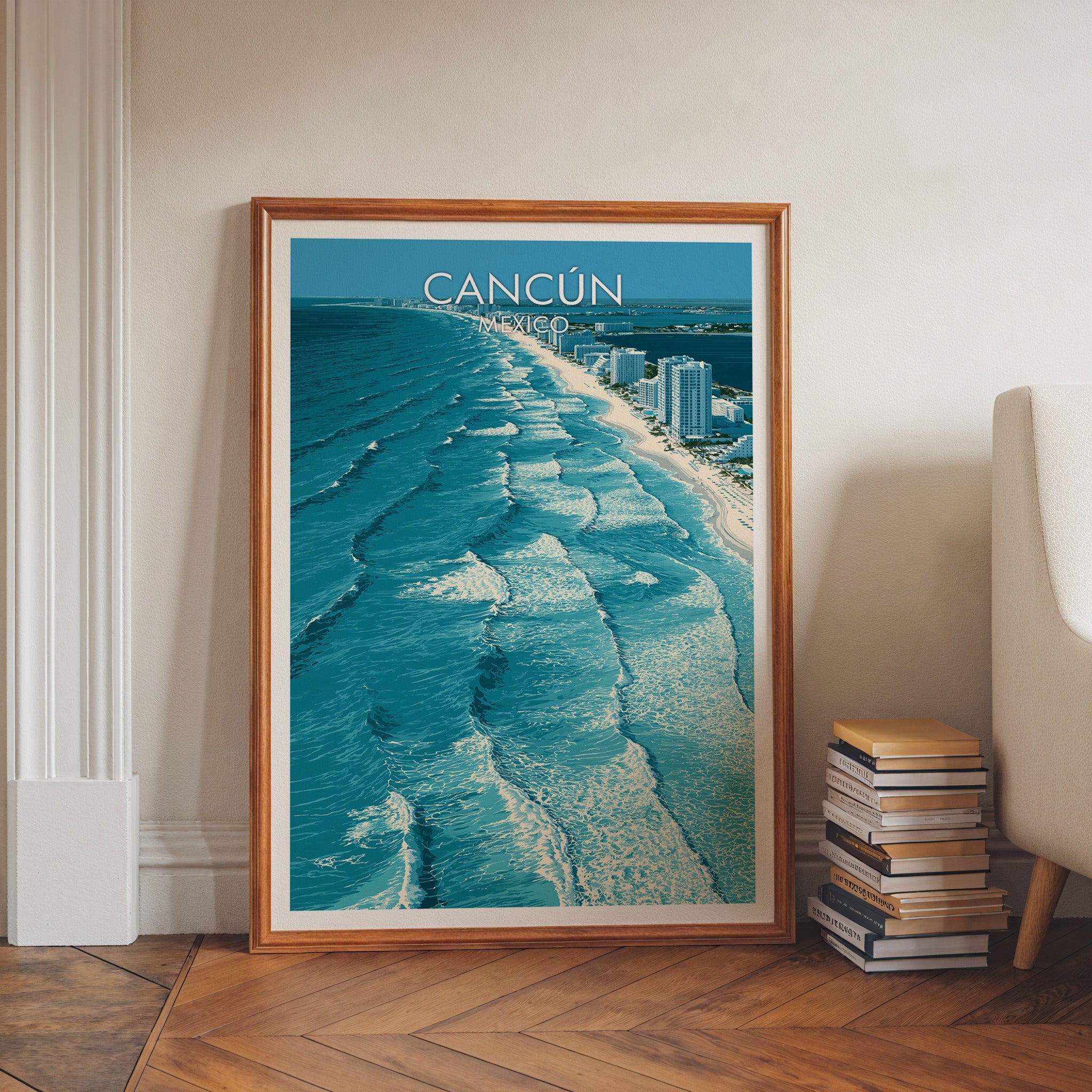 Yucatan beach travel art in a walnut frame leaning on a herringbone floor beside stacked books.