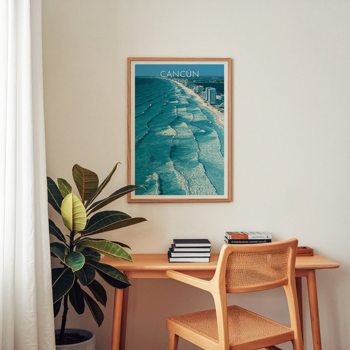 Surf and sand strip poster in an oak frame above a wooden home-office desk with a cane chair.