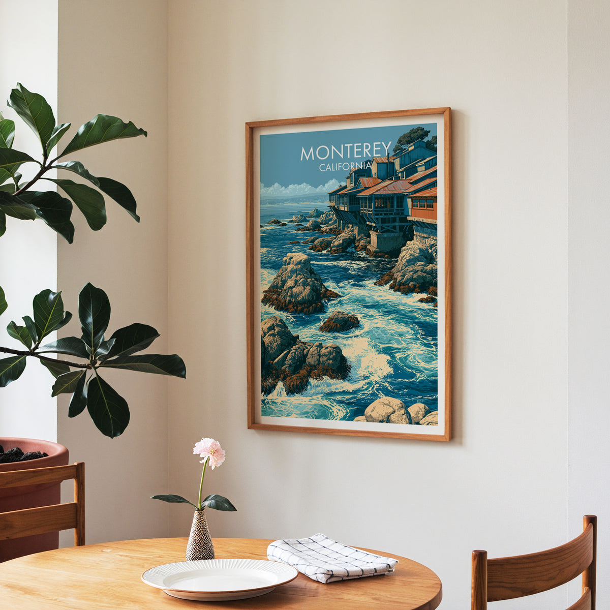 Monterey travel print in a walnut frame in a dining corner with a round table and a fiddle-leaf fig