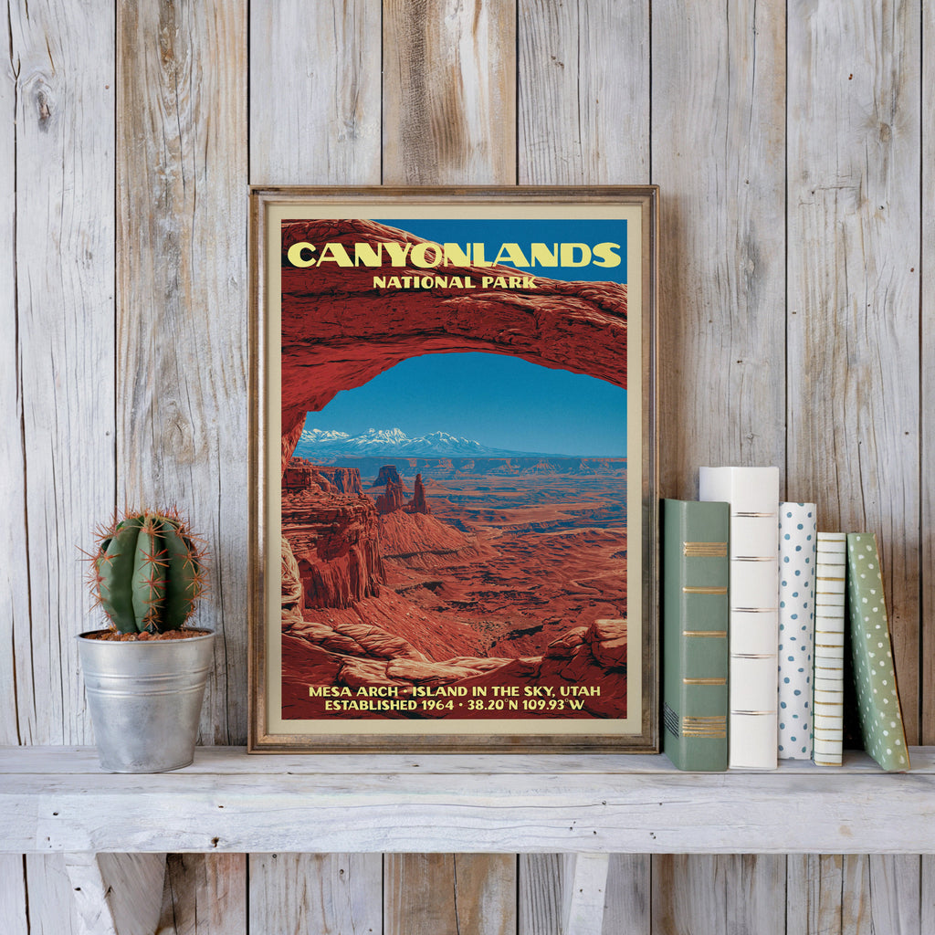 Canyonlands vintage poster in a slim gold frame on a whitewashed plank wall beside a cactus and books