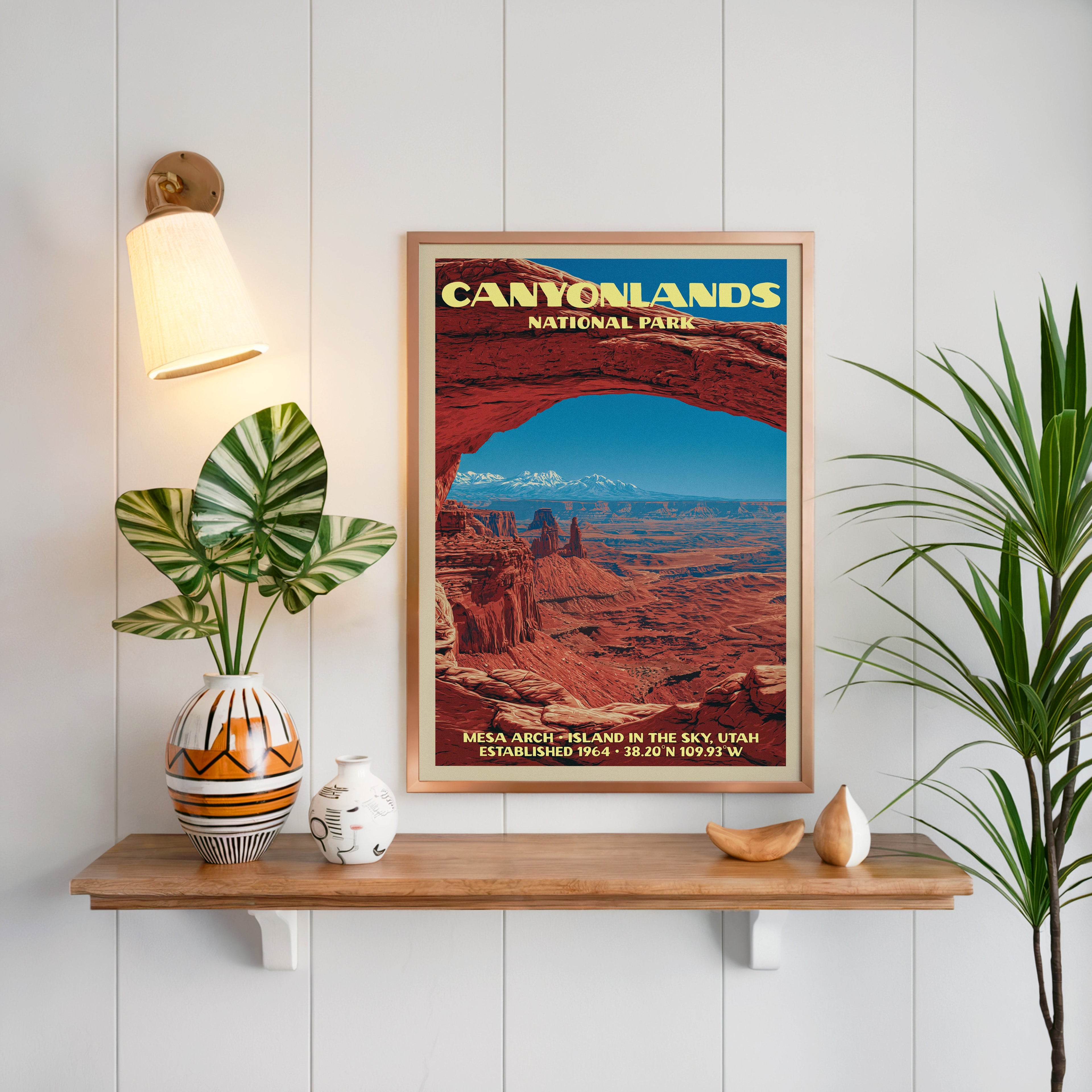 Mesa Arch Canyonlands print framed on white panelling above an oak shelf with a vase and a wall sconce