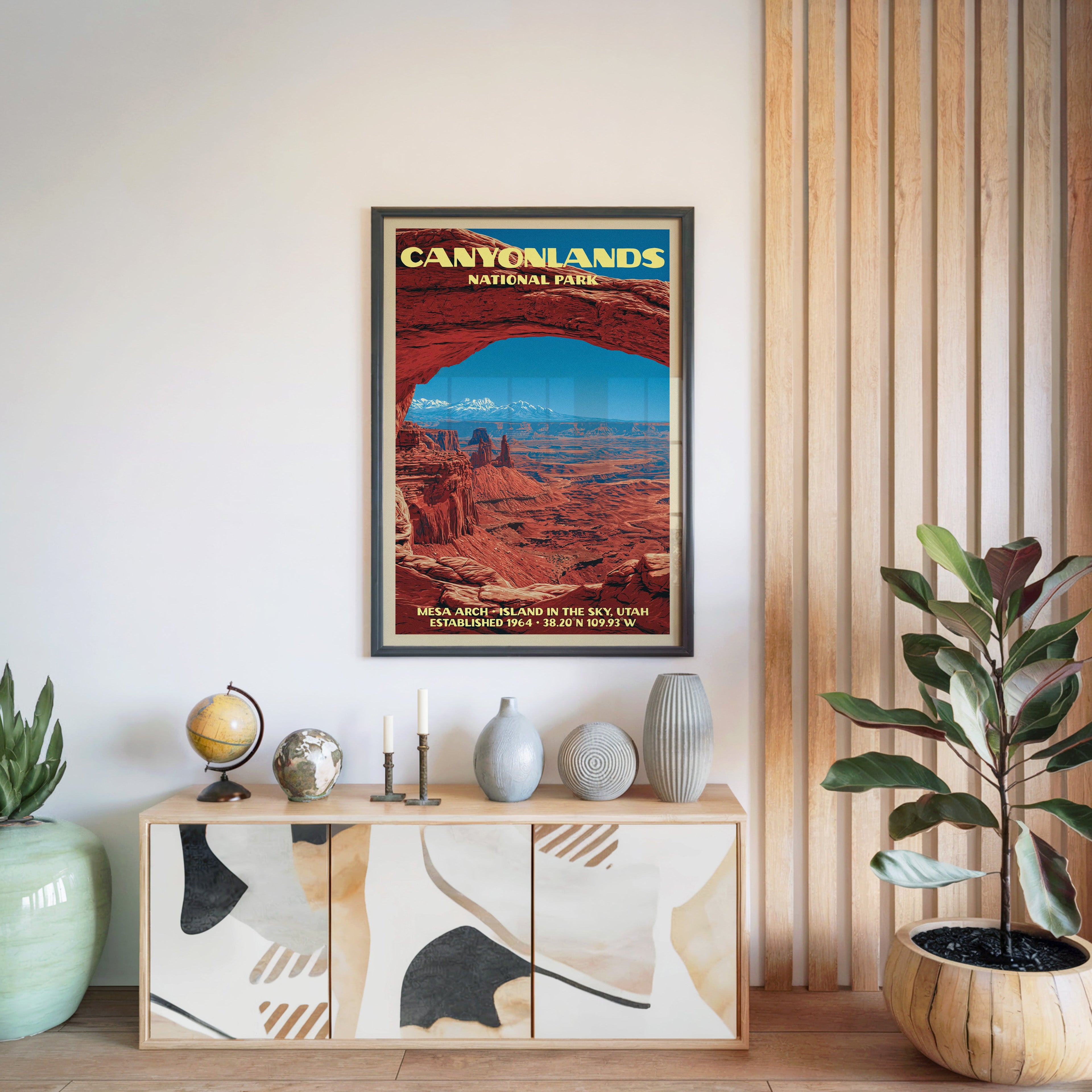 Canyonlands National Park poster in a black frame above a light wood sideboard by a slatted wall panel