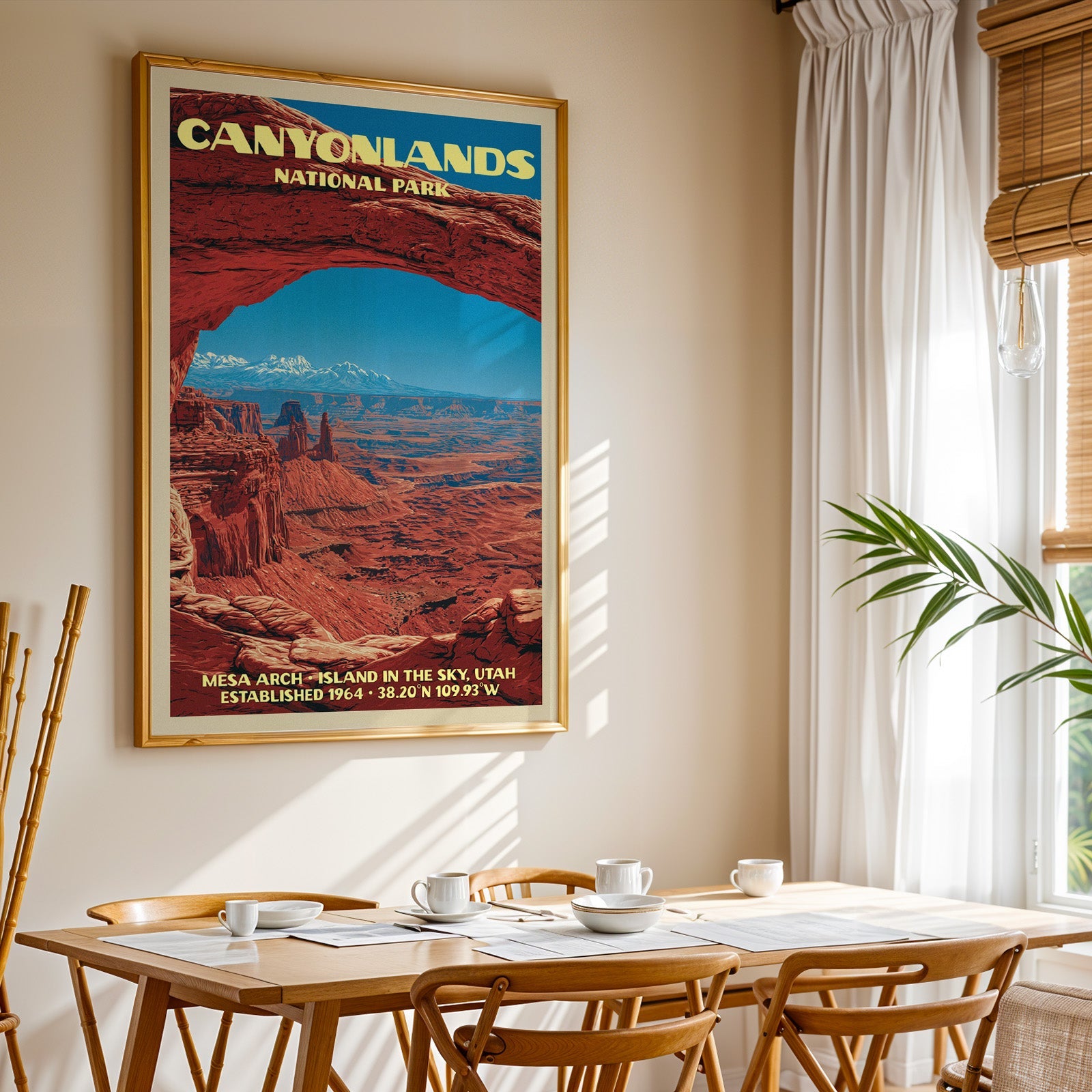 Canyonlands National Park print in gold above a light oak dining table by a curtained window