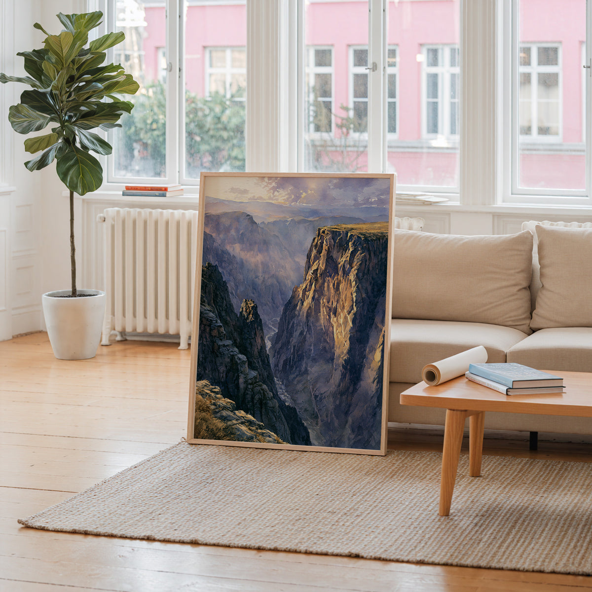 Black Canyon of the Gunnison watercolor art print leaning against a living room wall beside a linen sofa and coffee table