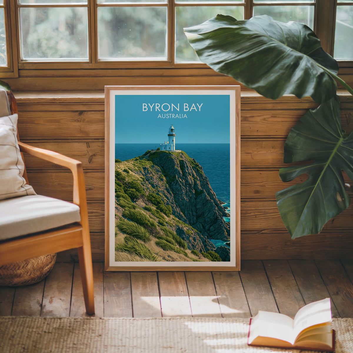Coastal lighthouse artwork in an oak frame against a pine cabin wall with a wooden armchair and jute rug