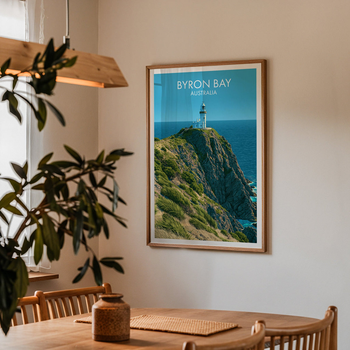 Cape Byron print in an oak frame in a dining corner with oak table, spindle chairs and a wood pendant light