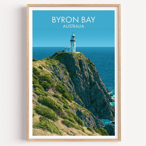 Cape Byron Lighthouse travel print in a light oak frame on a plain white wall