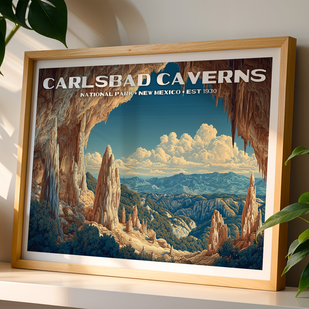 Carlsbad Caverns National Park wall art print in a light oak frame, leaning on a white shelf in warm sunlight beside a monstera plant