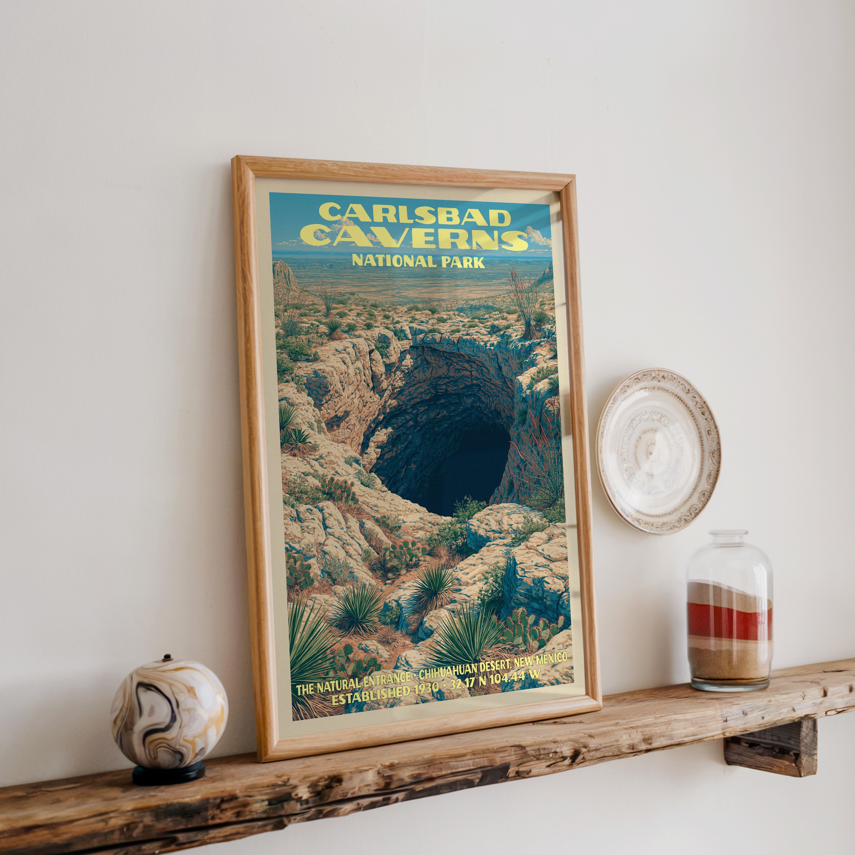 Carlsbad Caverns Natural Entrance print in oak, leaning on a reclaimed wood ledge with a stone sphere and sand jar