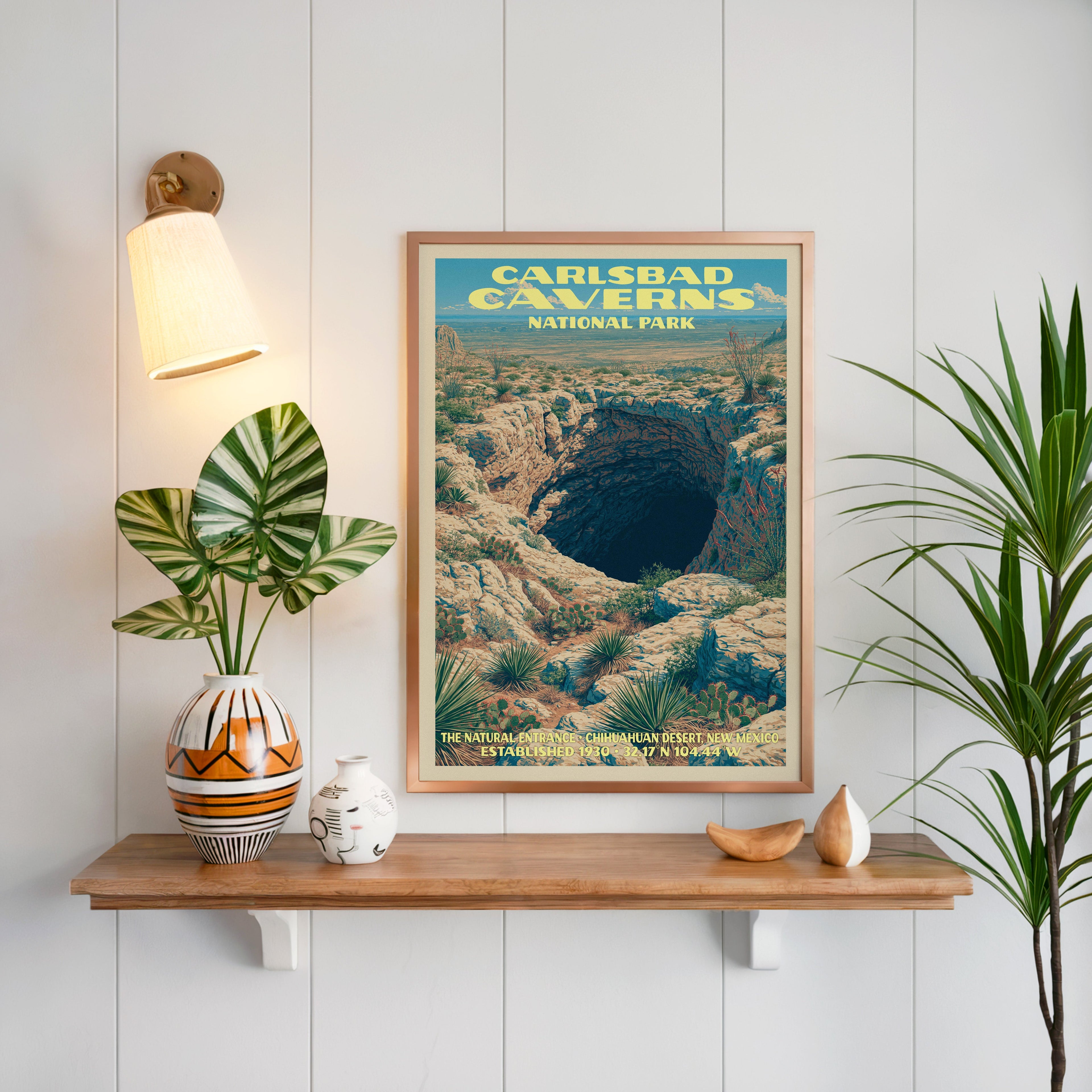 Natural Entrance Carlsbad Caverns print framed on white panelling above an oak shelf with a patterned vase