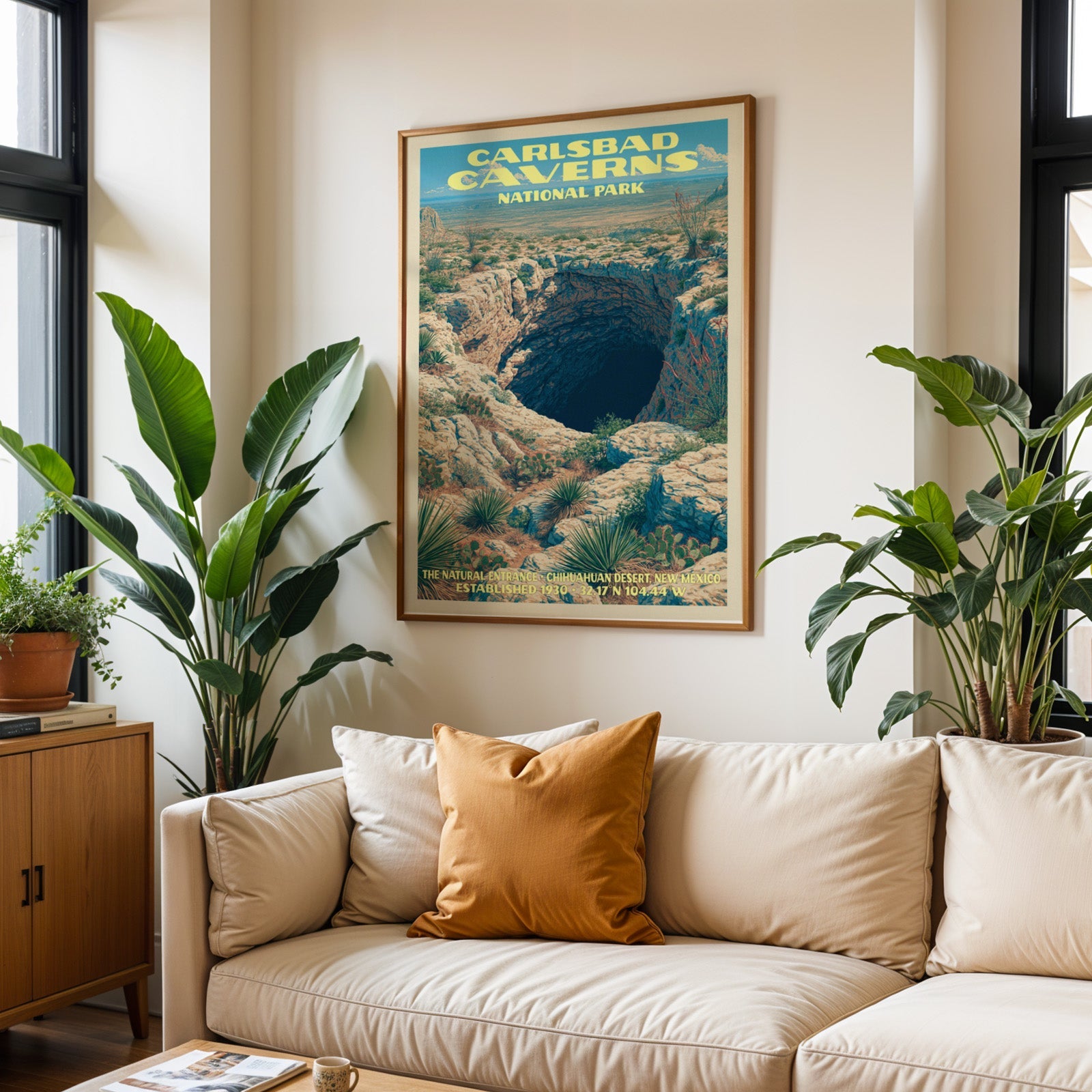 Carlsbad Caverns vintage travel print in oak above a cream sofa with a rust cushion and tall houseplants