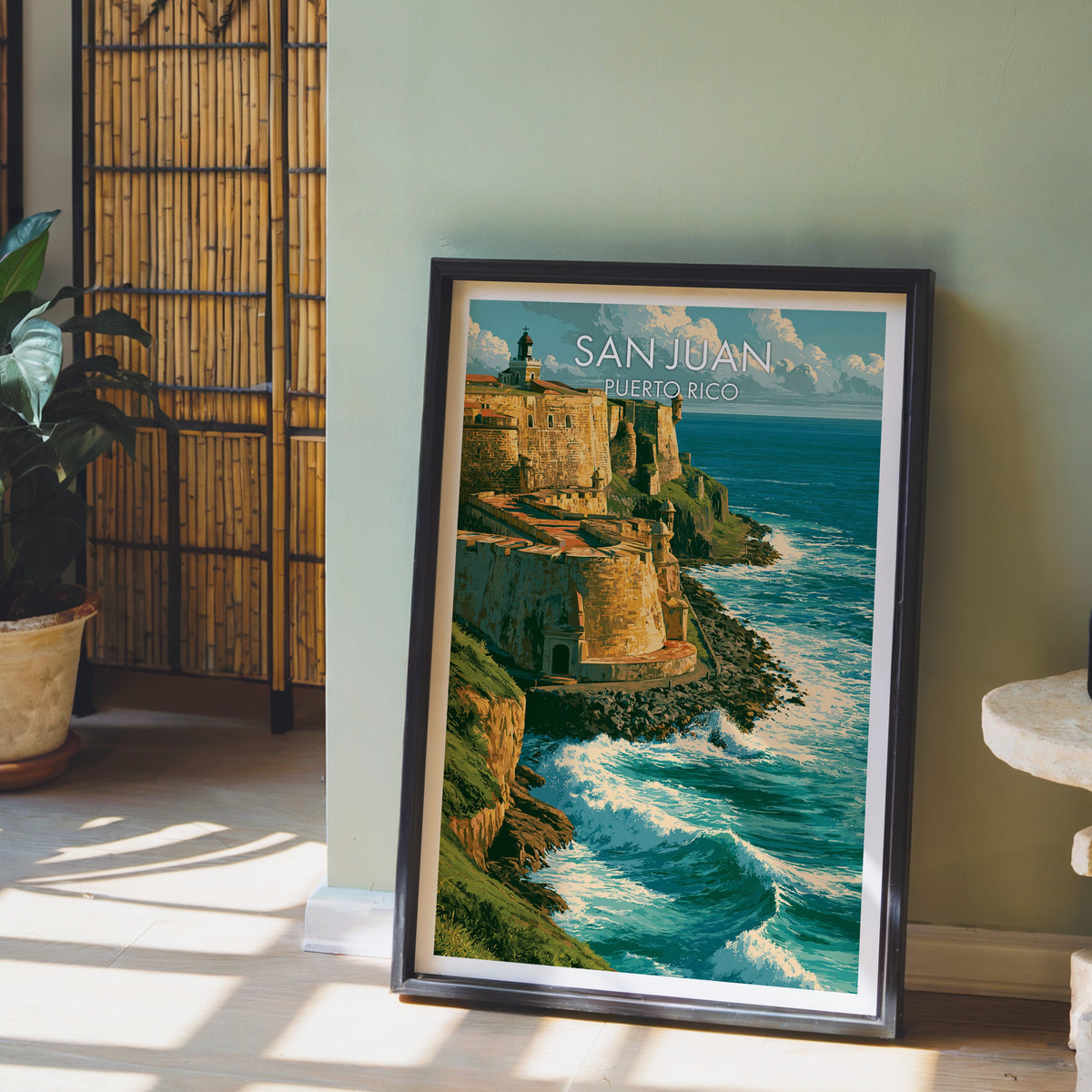 Domed sentry box print in a black frame leaning on pale wood floor, sage-green wall, bamboo screen and a plant