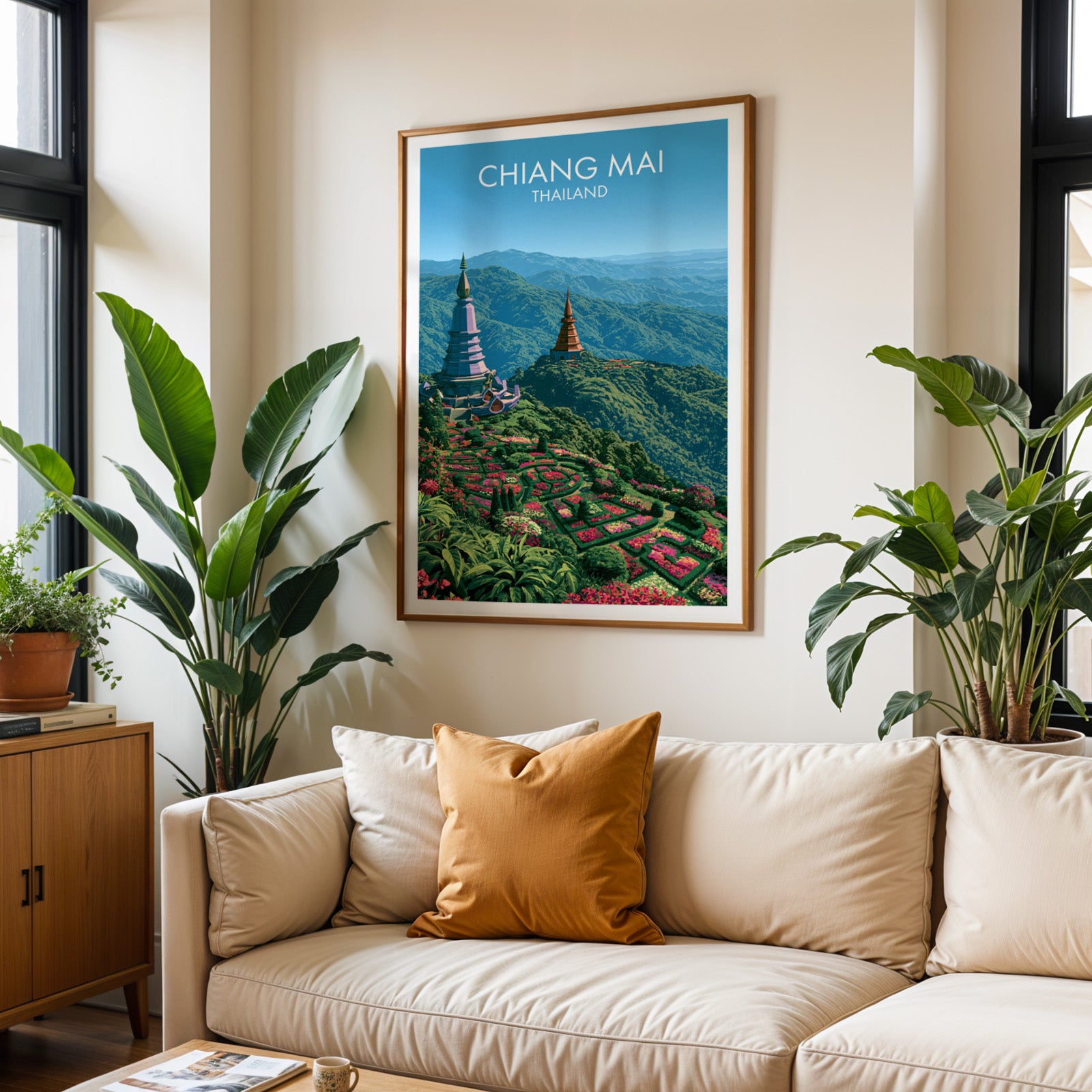Framed Chiang Mai Thailand wall art hanging above a cream sofa in a bright living room with tropical plants