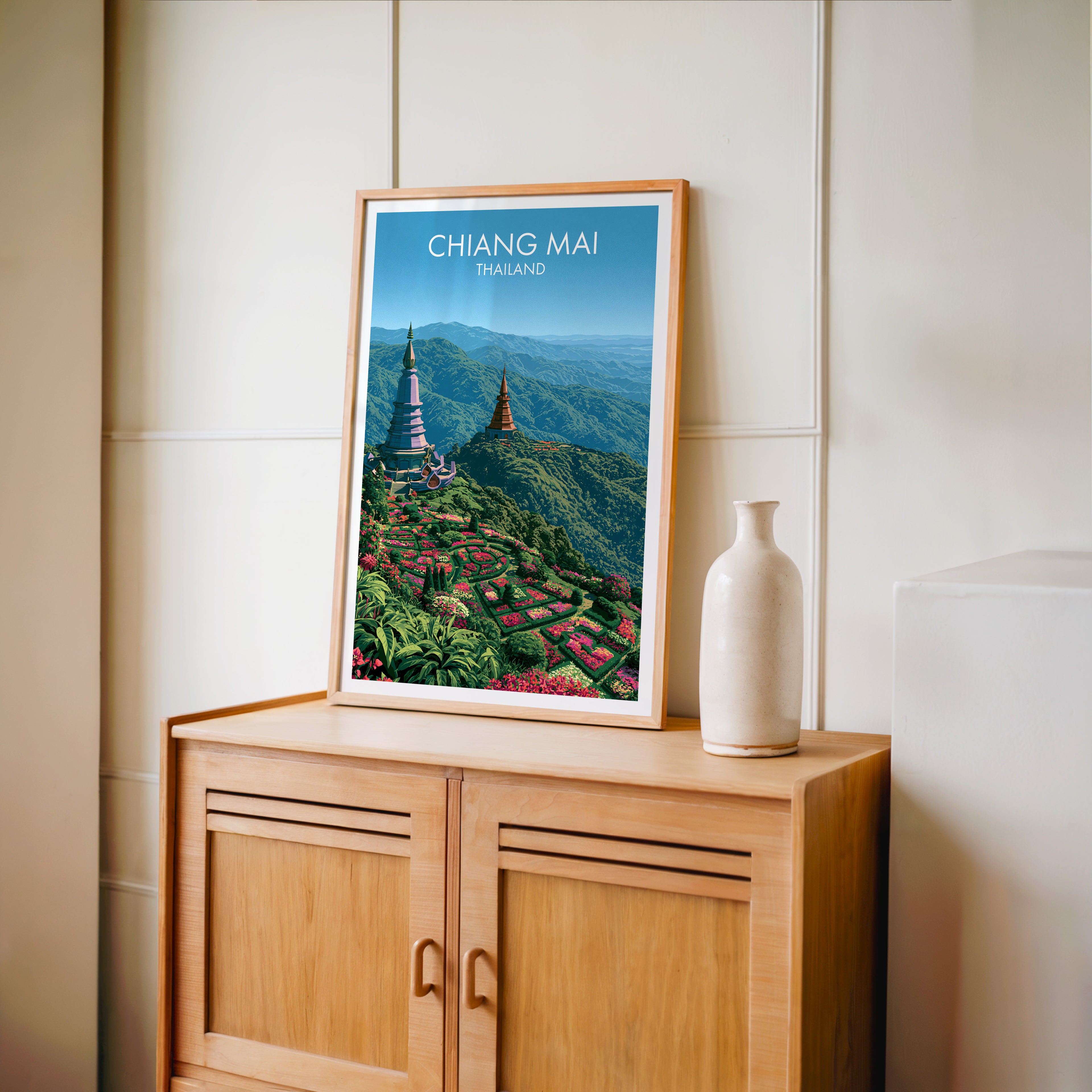 Small Chiang Mai Thailand travel poster in an oak frame on a mid-century sideboard with a ceramic vase
