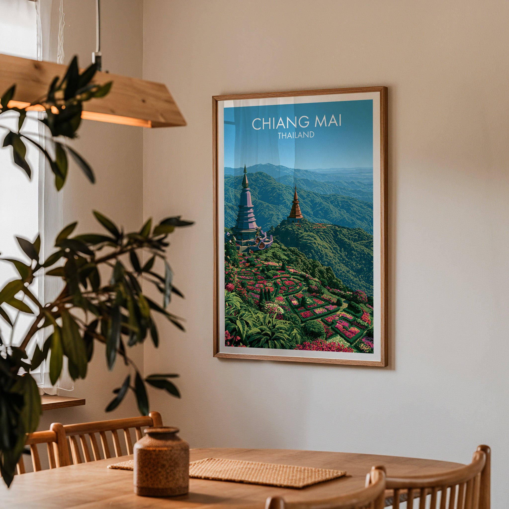 Framed Chiang Mai Thailand print on a dining room wall above an oak table in warm afternoon light