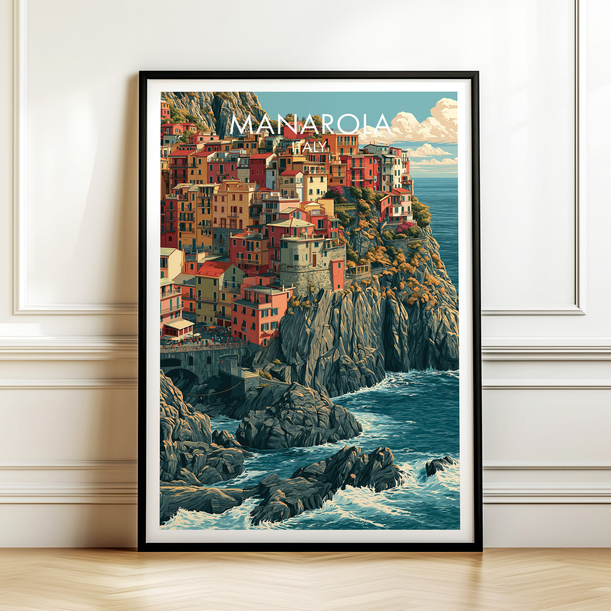 Manarola Cinque Terre print in a black frame leaning against a white panelled wall on a herringbone floor
