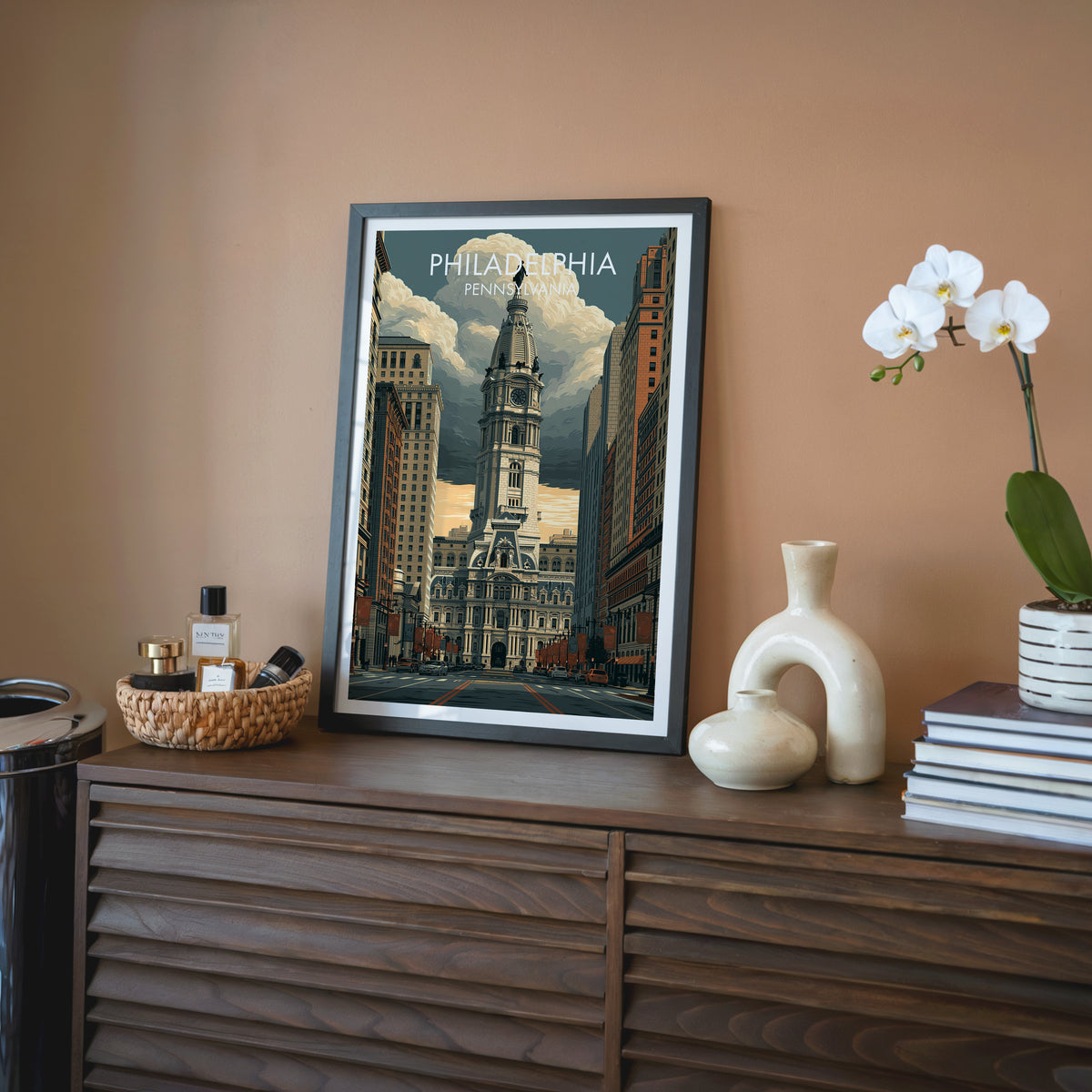 Broad Street wall art in a black frame on a walnut sideboard against a terracotta wall with an orchid