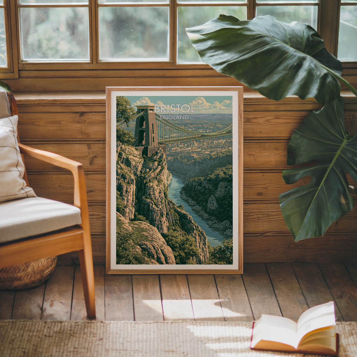 Clifton Suspension Bridge poster, oak frame leaning on a wood-panelled sunroom wall by a mid-century armchair