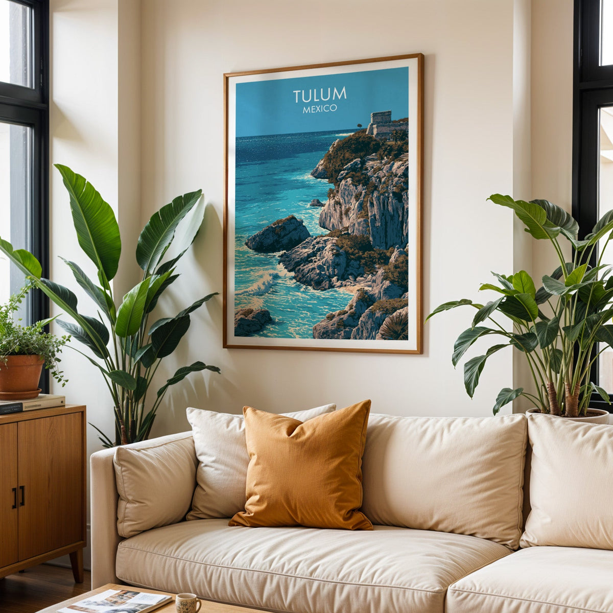 Surf breaking on pale boulders, oak frame above a cream sofa with a burnt-orange cushion and plants.