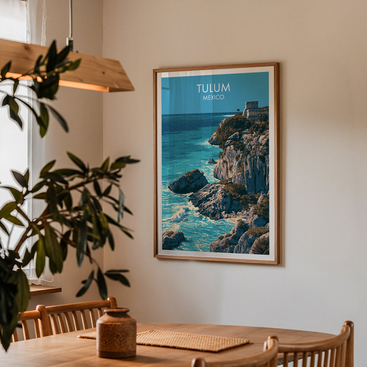Tulum coastline travel art in an oak frame in a dining corner with spindle chairs and a pendant lamp.