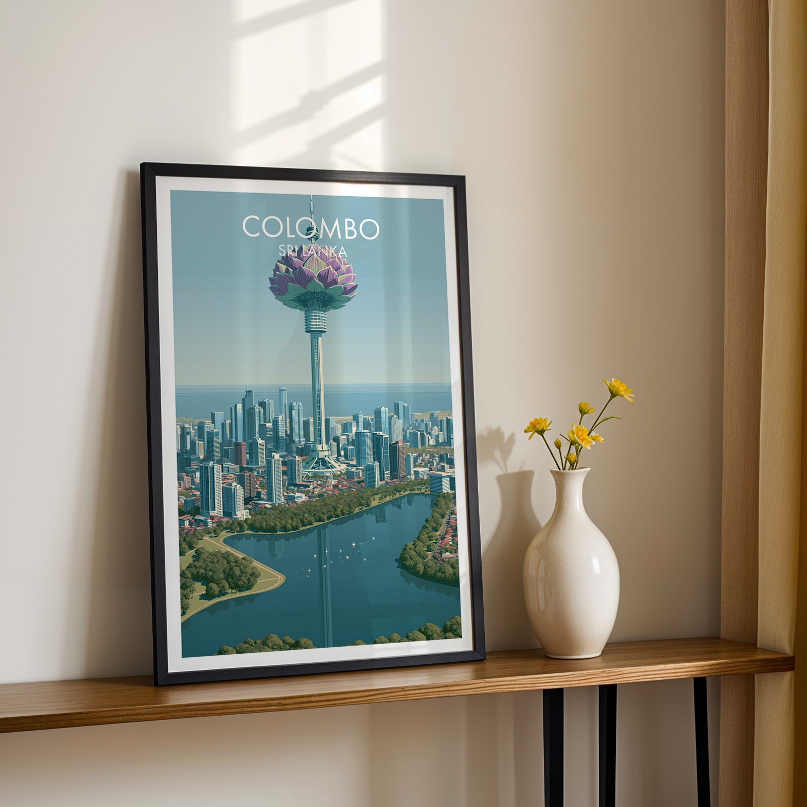 Black framed Colombo Sri Lanka print on a narrow hallway console in sunlight, styled with yellow flowers