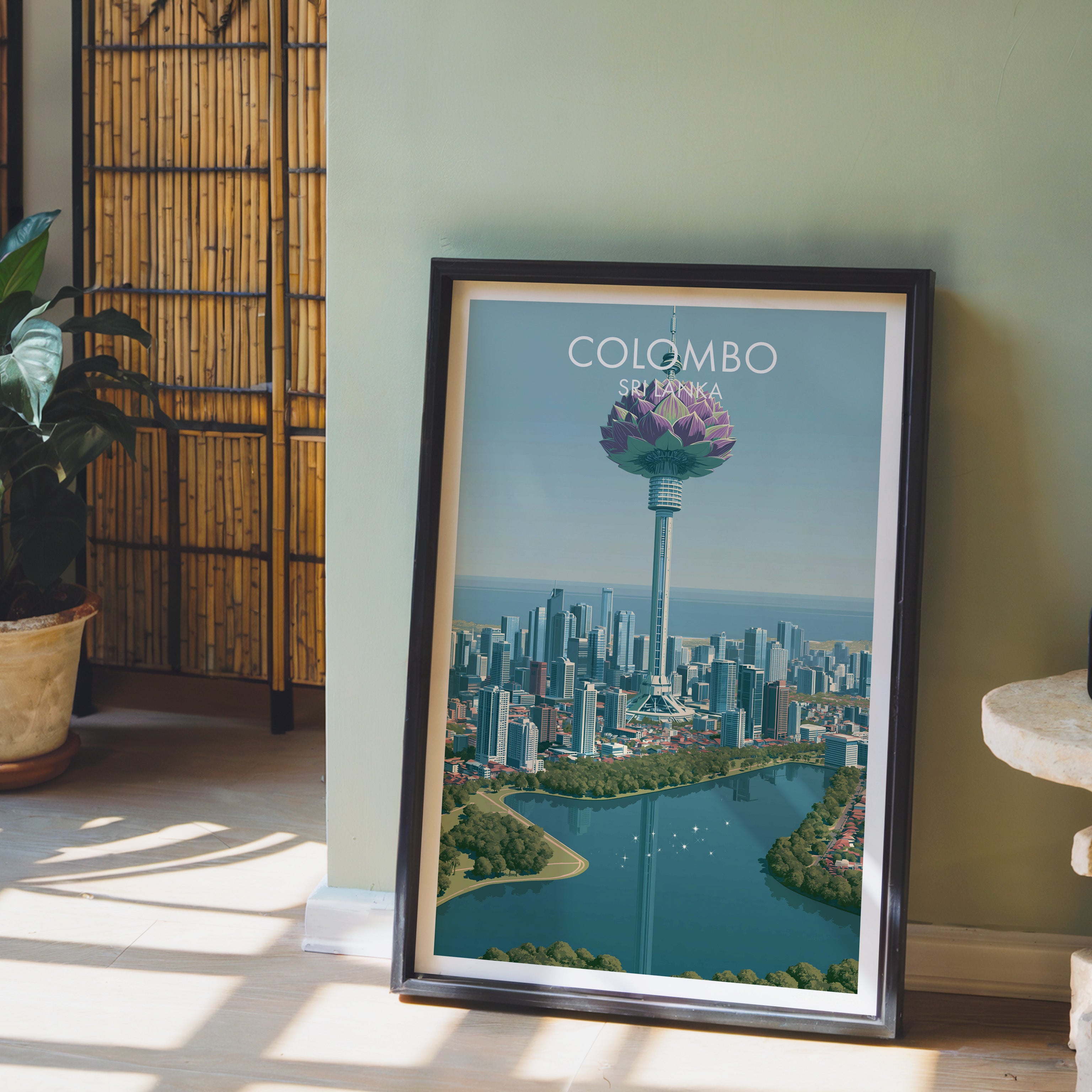 Colombo Sri Lanka wall art in a black frame leaning against a sage green wall beside a bamboo screen
