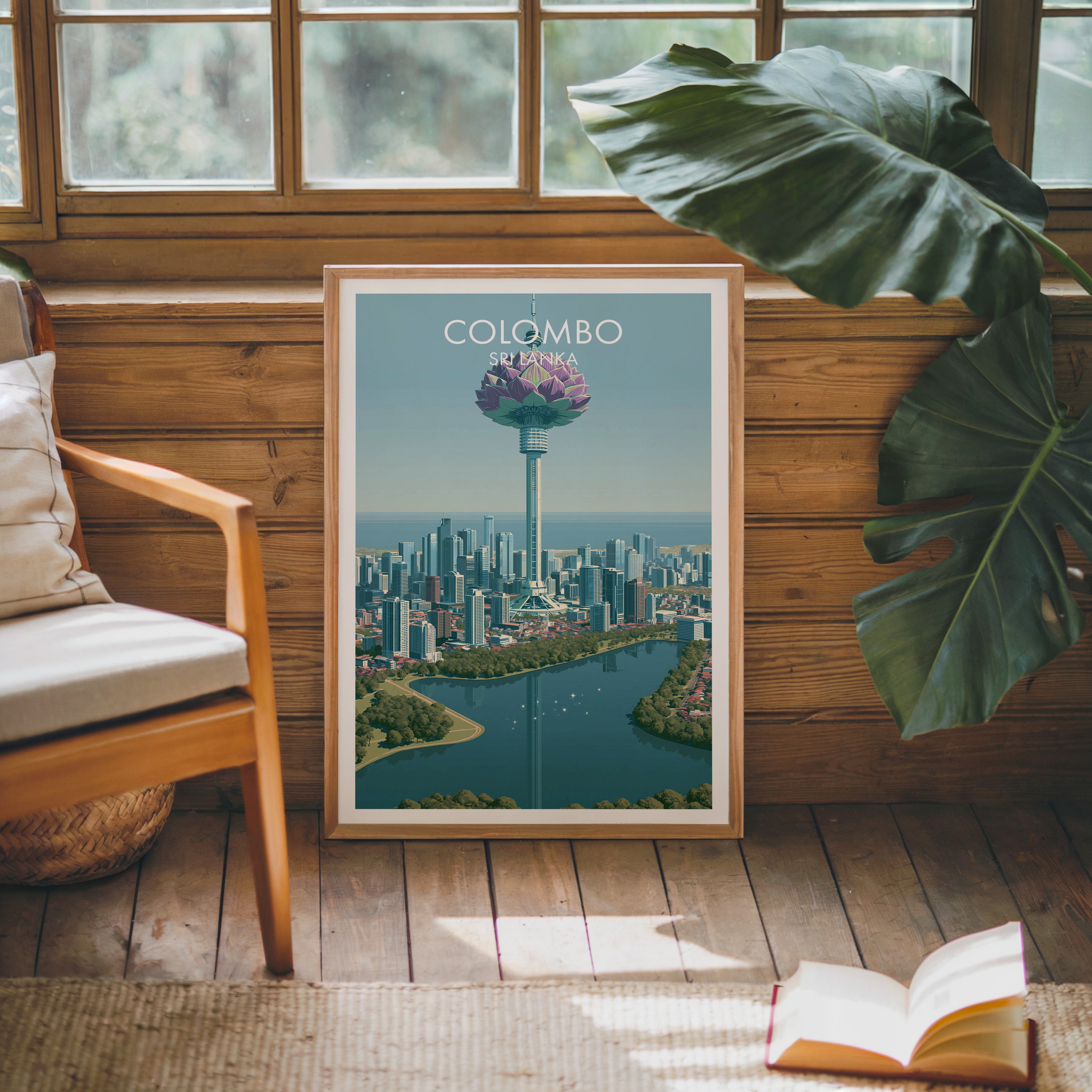 Framed Colombo Sri Lanka poster leaning against a timber cabin wall with monstera leaves and an open book