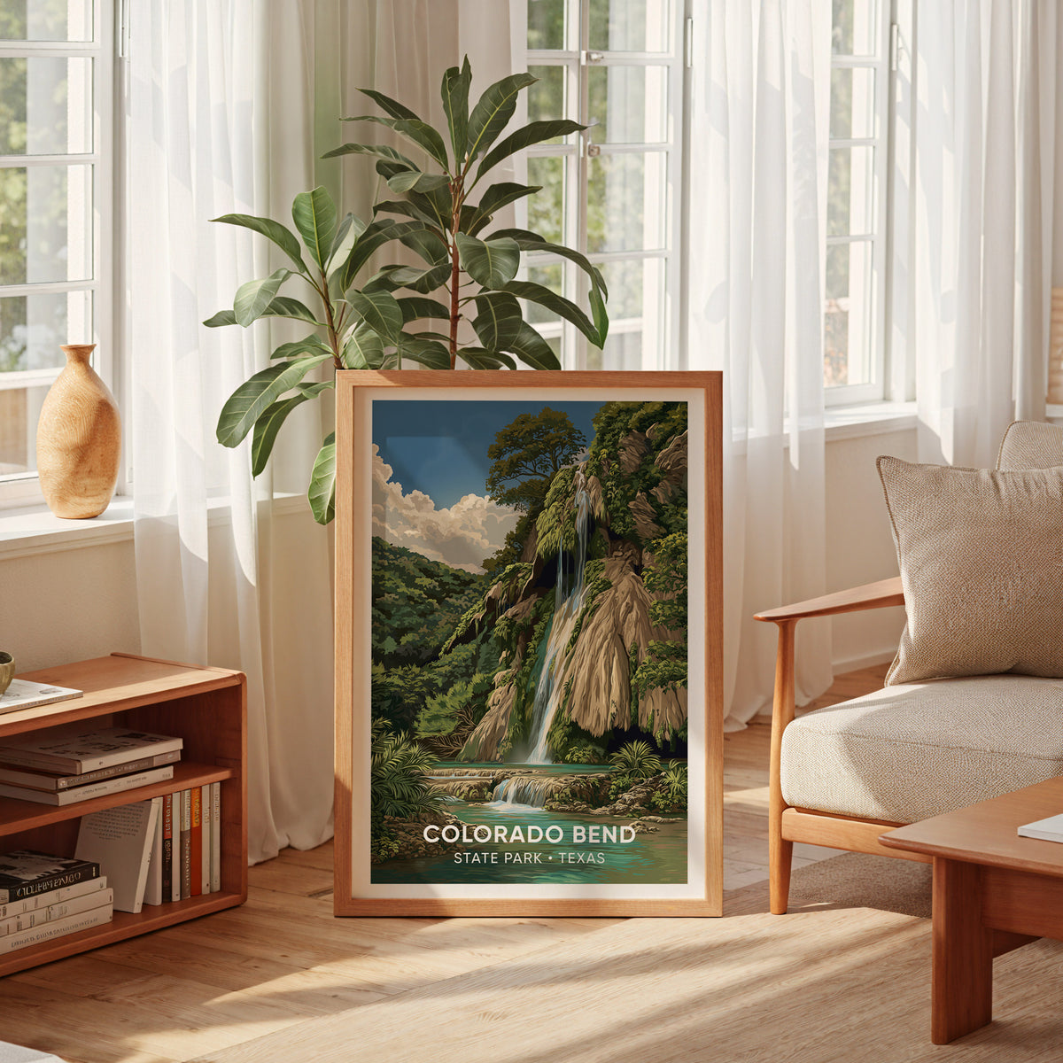 Colorado Bend State Park print in an oak frame by a sheer-curtained window with a low bookshelf.