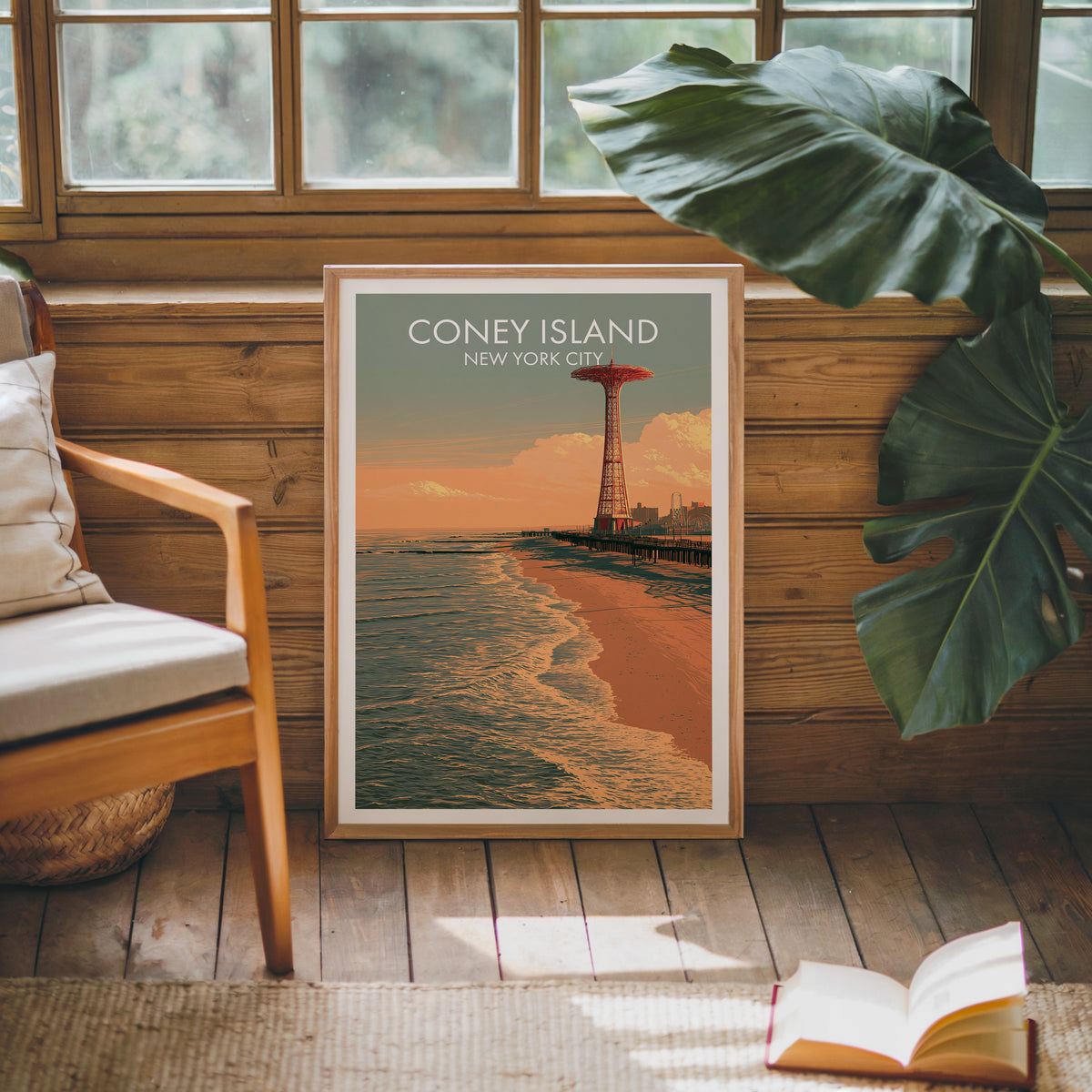 Sunset surf print in an oak frame on a sunlit wood wall beside a mid-century armchair and monstera leaves.
