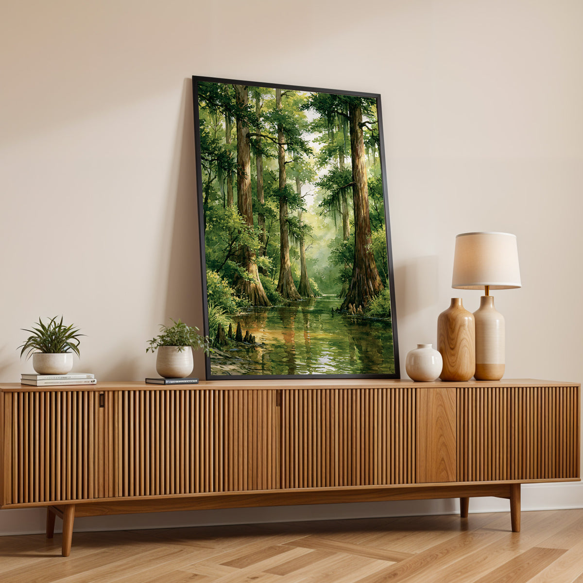 Congaree National Park watercolor print in a black frame on a fluted wood sideboard with a lamp and small plants