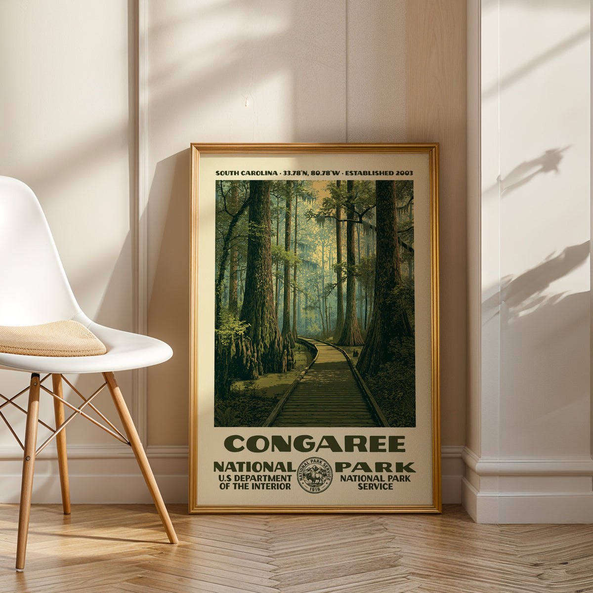 Congaree National Park vintage WPA art in an oak frame leaning by a white chair on a wood floor