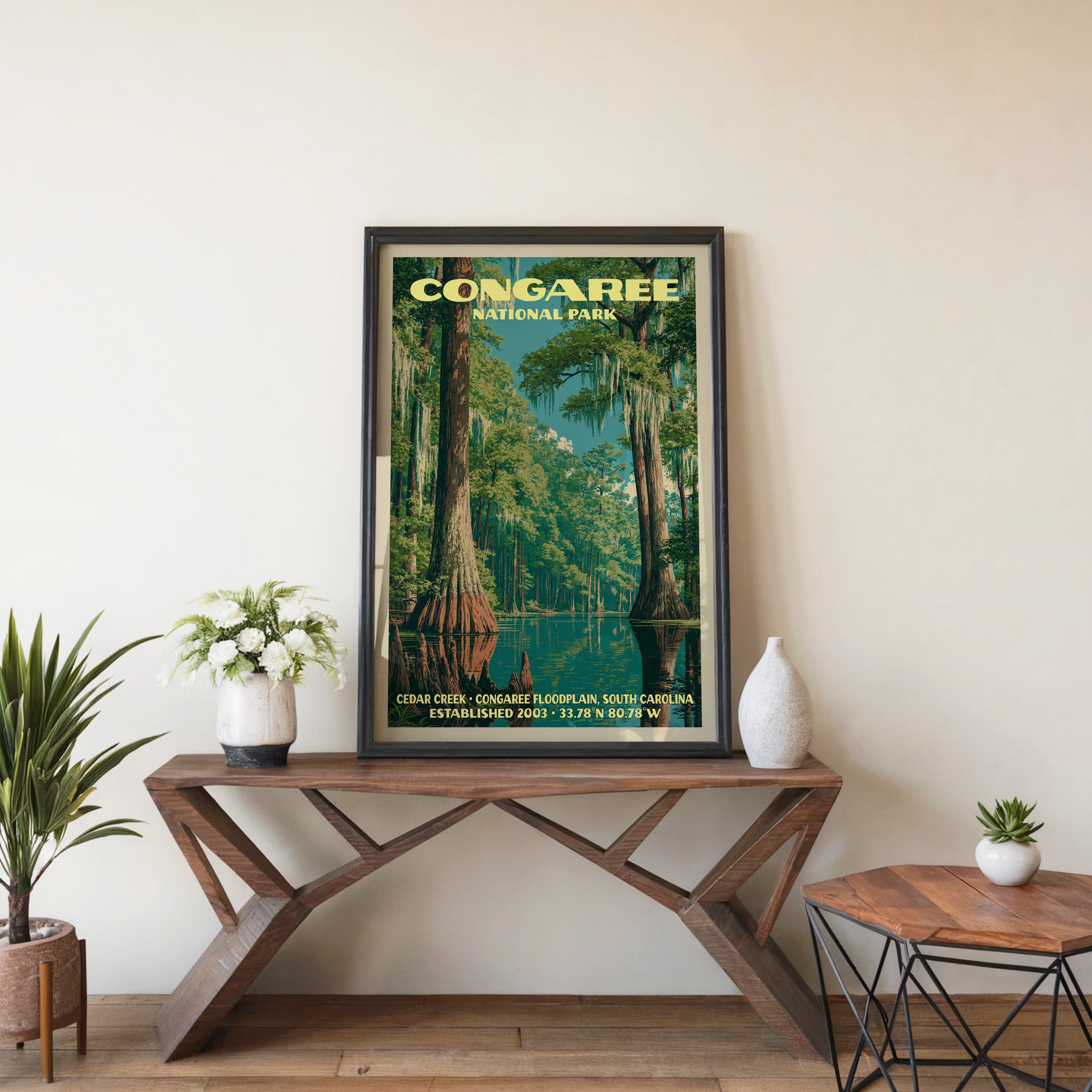 Congaree Cedar Creek wall art in black, leaning on a walnut console with white anemones and a vase