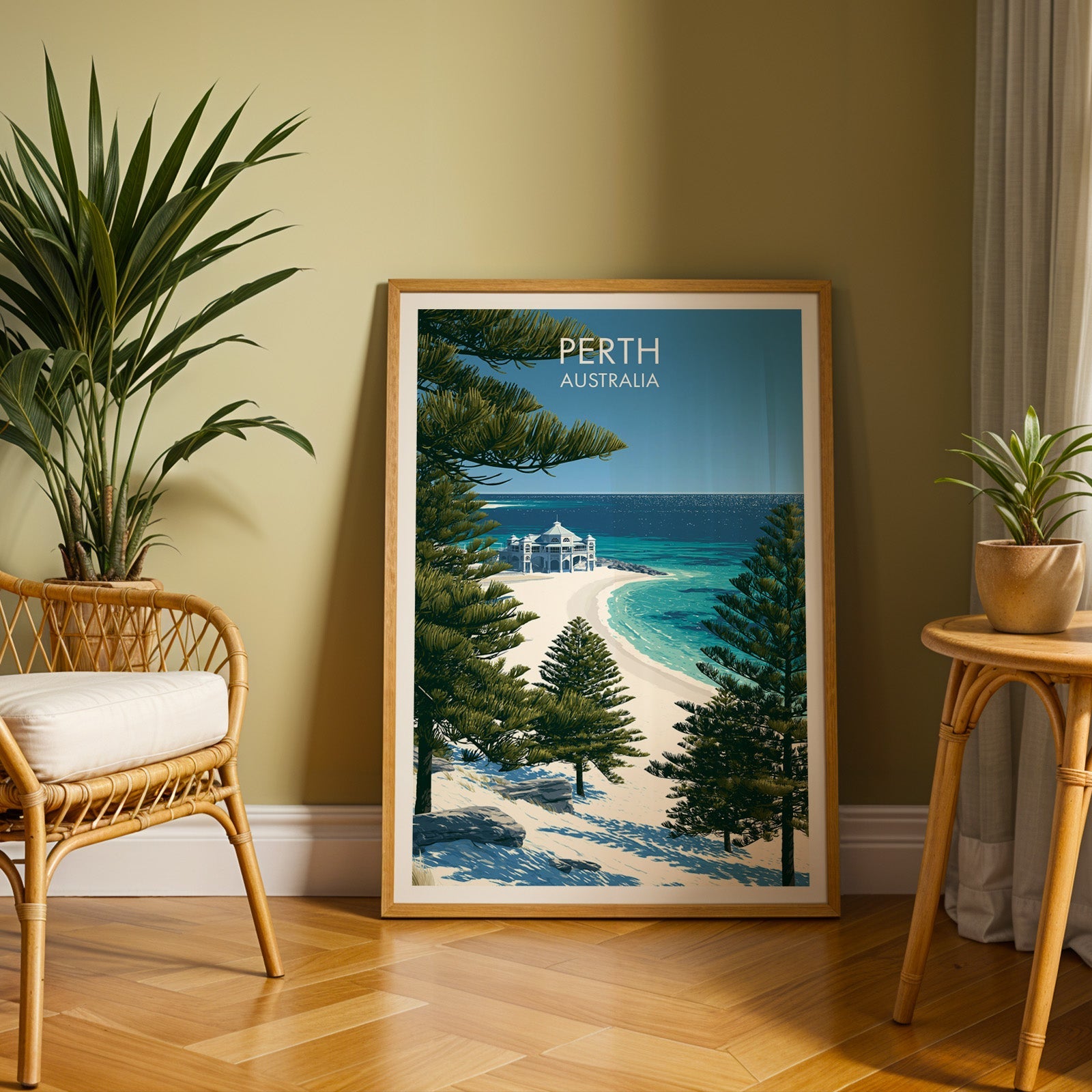 Perth coastal poster in an oak frame on herringbone parquet, olive wall, rattan chair and plant