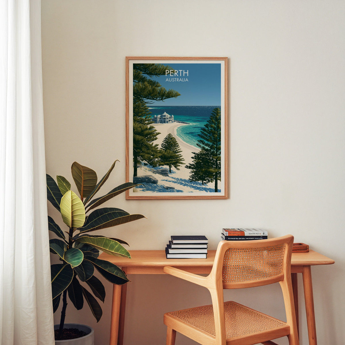 Coastal Perth artwork in an oak frame above a home office desk with a cane chair and rubber plant