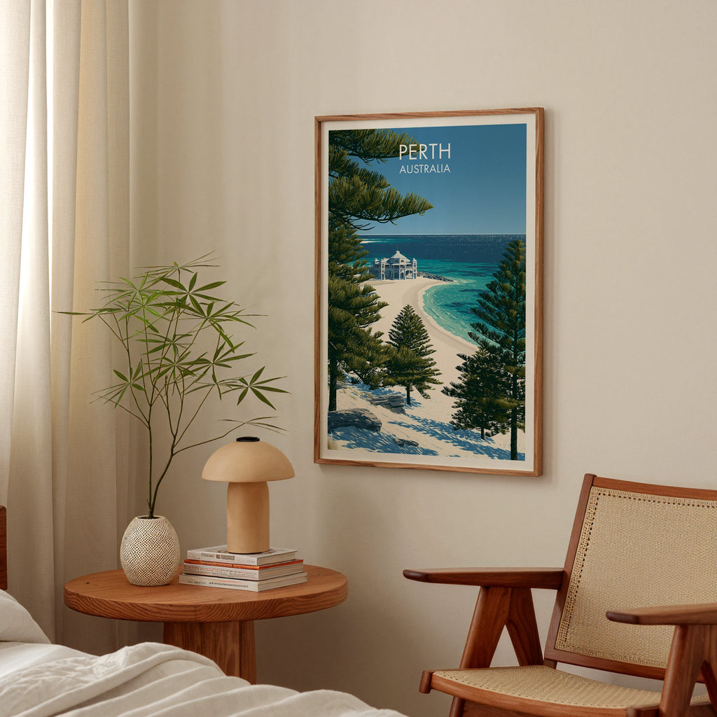 Framed pine and ocean print in a bedroom above a bedside table with a mushroom lamp and cane armchair