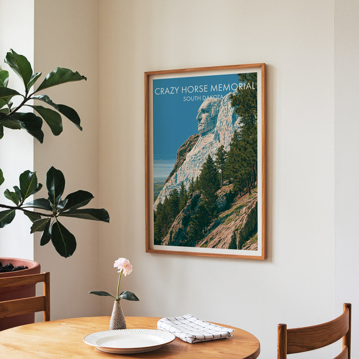 Black Hills wall art in a walnut frame in a dining corner with a round table, roses and a fiddle-leaf fig.
