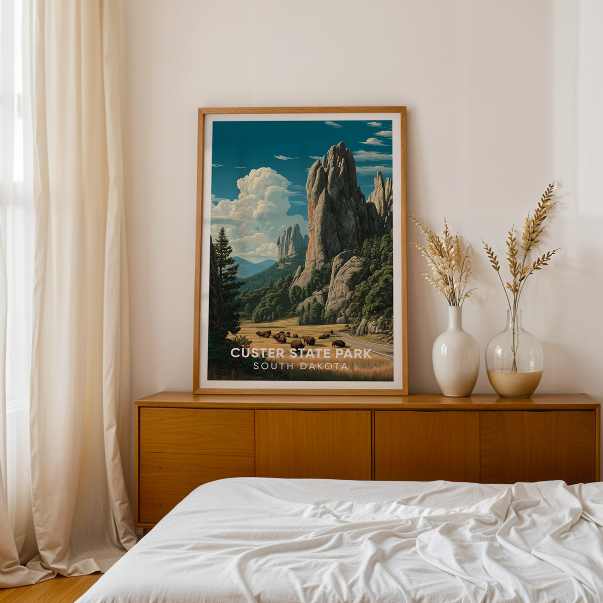 Custer State Park wall art on a teak sideboard beside a bed with dried pampas in white vases
